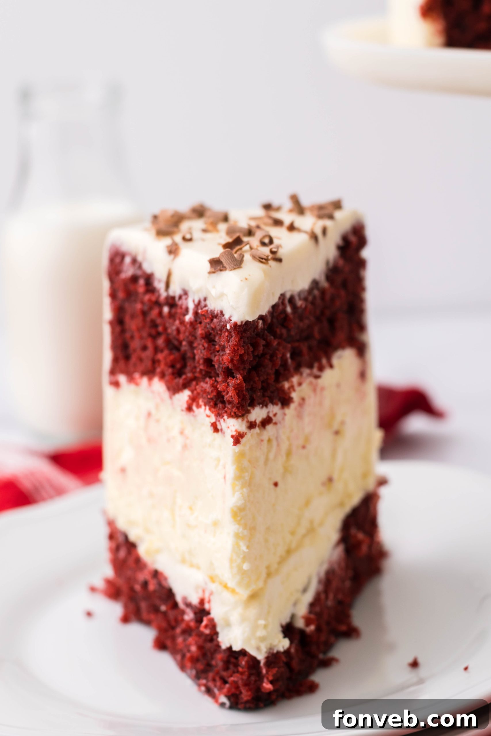 A full Red Velvet Cheesecake Cake on a cutting board, with a knife indicating it's ready to be served.