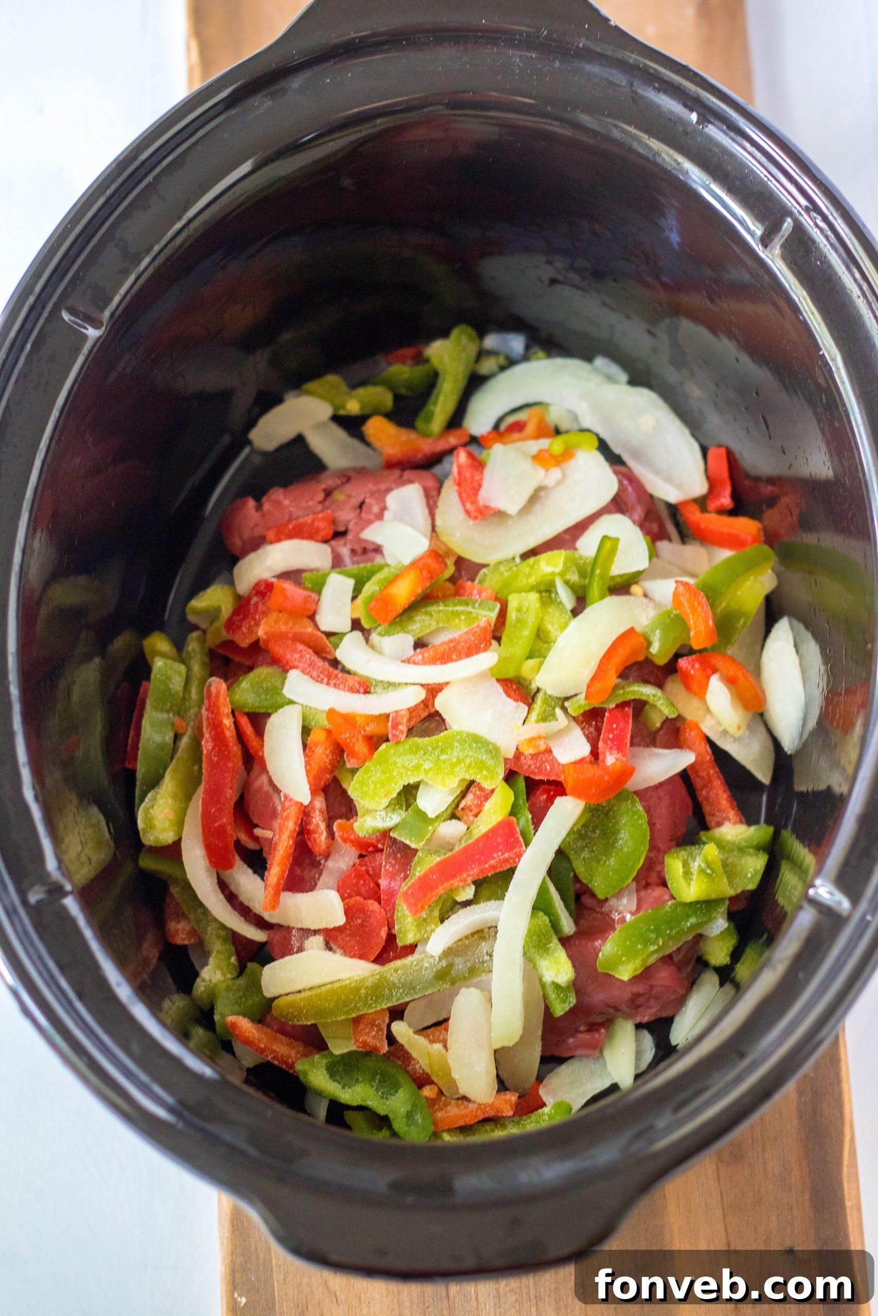 Hearty Slow Cooker Pepper Steak with Onions 4 Serving of Slow Cooker Pepper Steak with rice on a plate.