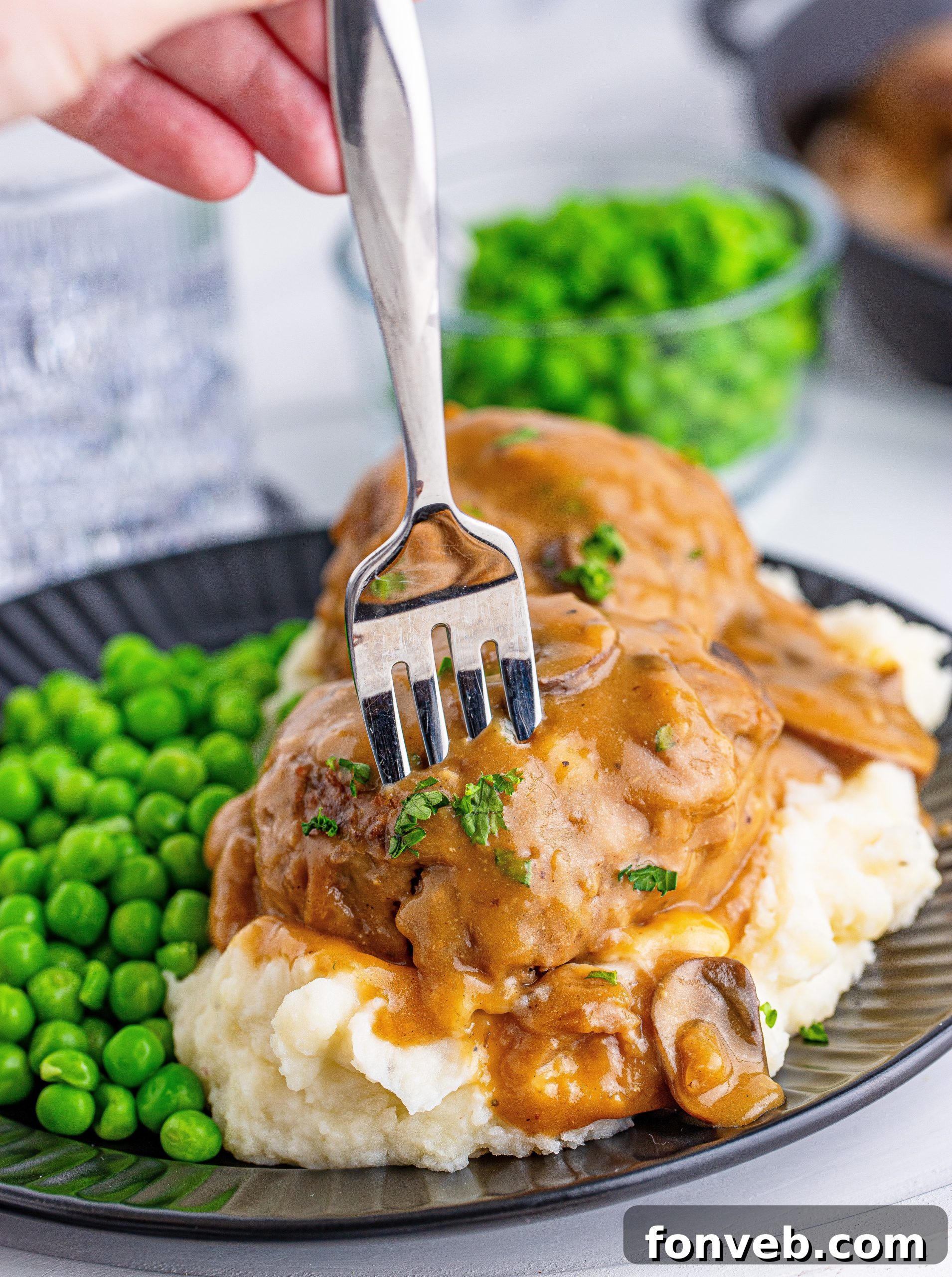 Hearty Salisbury Steaks with Rich Gravy 6 A serving of Salisbury Steaks with the luscious mushroom gravy, highlighting the texture of the meat and sauce.