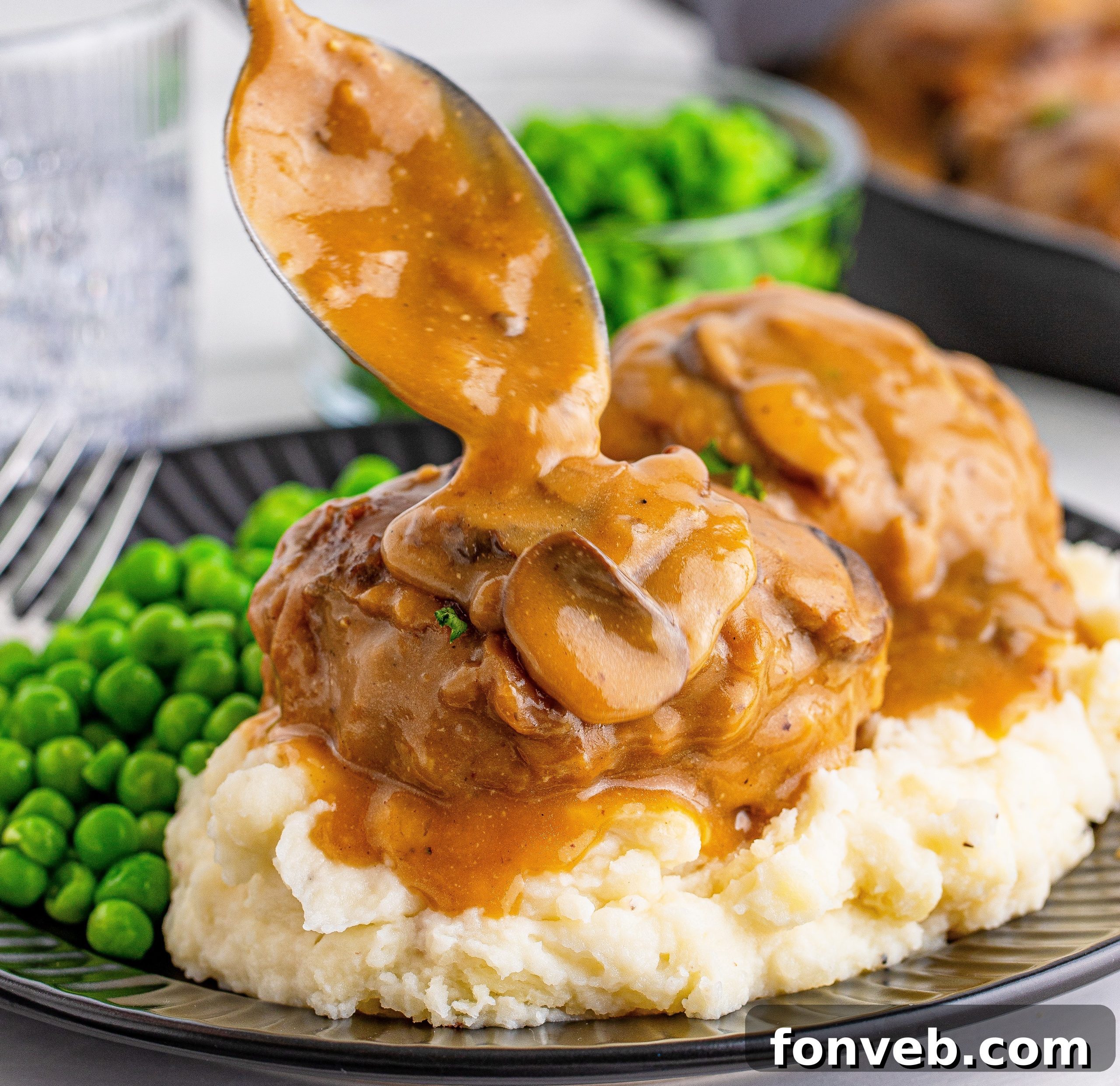 Hearty Salisbury Steaks with Rich Gravy 7 Close-up of two Salisbury Steaks in a cast iron skillet, browning beautifully.