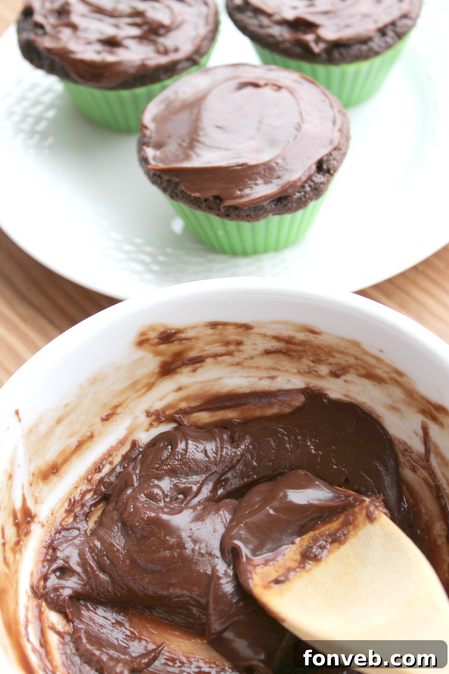 Cupcake batter being spooned into liners in a baking pan, ready for the oven.