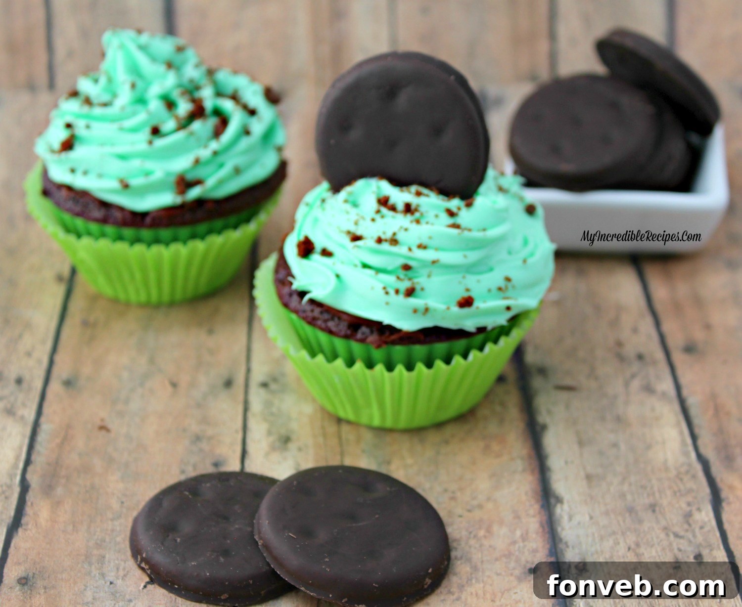 An array of finished Thin Mint Cupcakes, beautifully frosted and decorated with whole and crushed Thin Mint cookies.