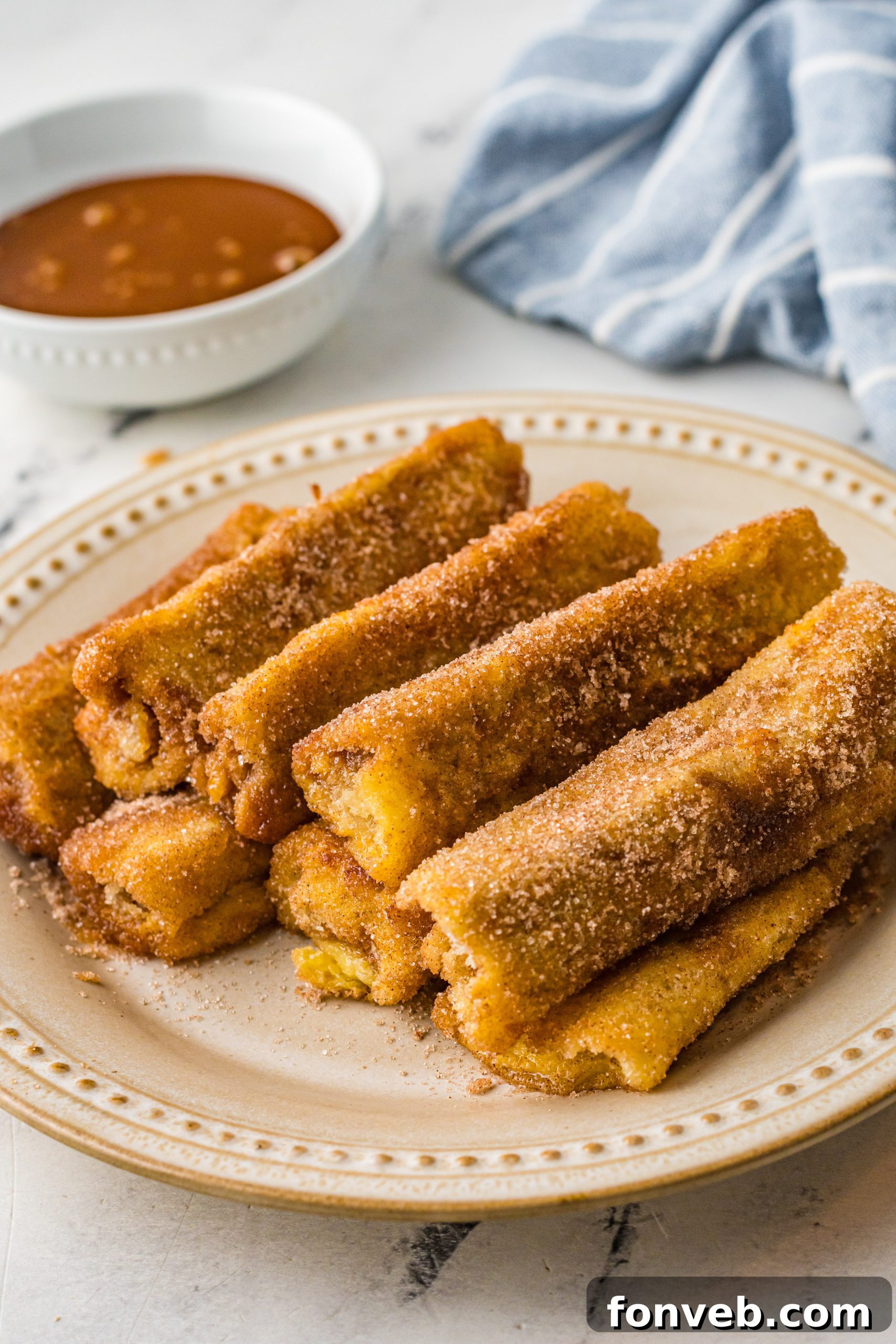 A large platter filled with Churro French Toast Roll Ups, perfect for sharing at a gathering.