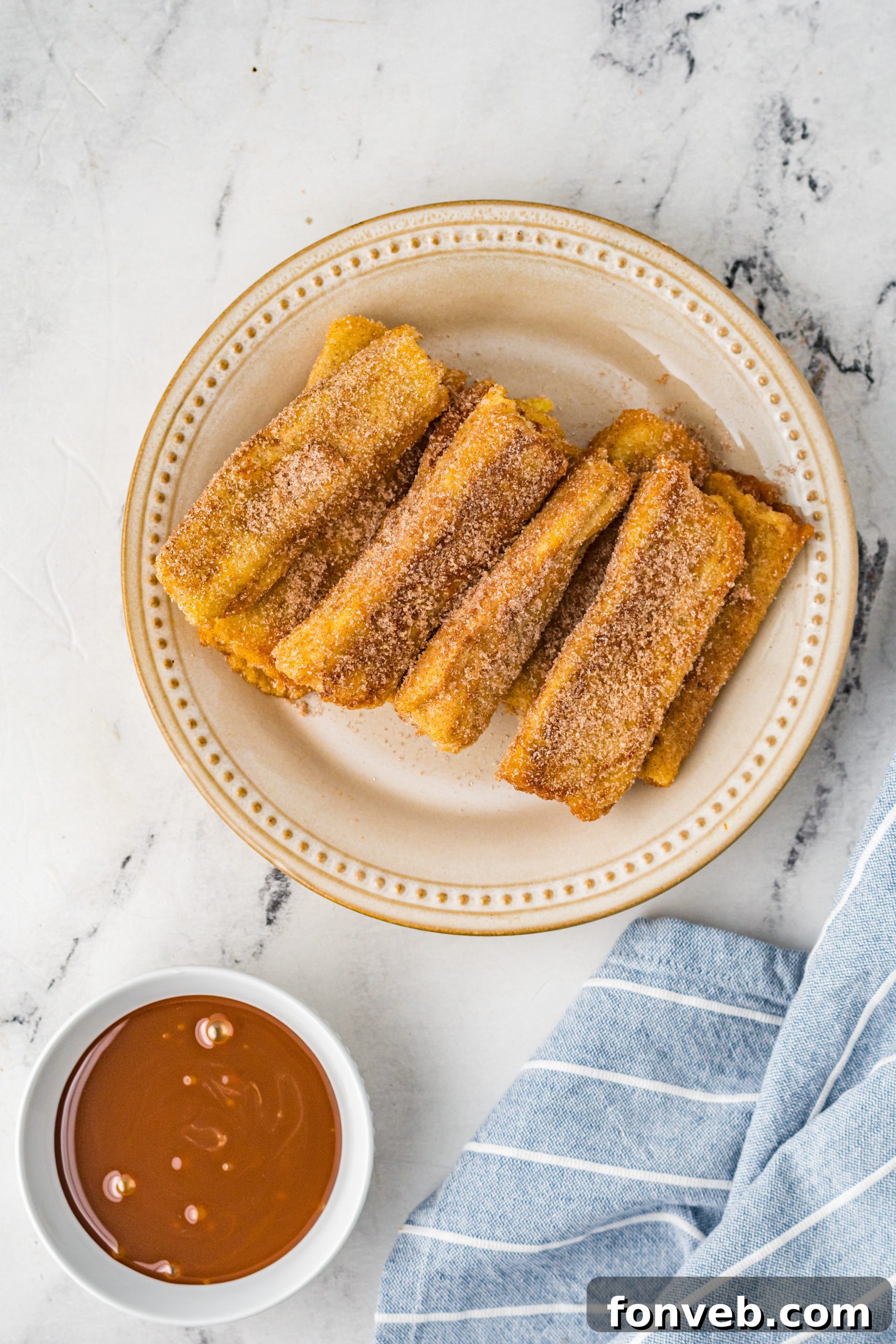 Churro French Toast Roll Ups artfully arranged on a wooden serving board, showcasing their inviting appearance.