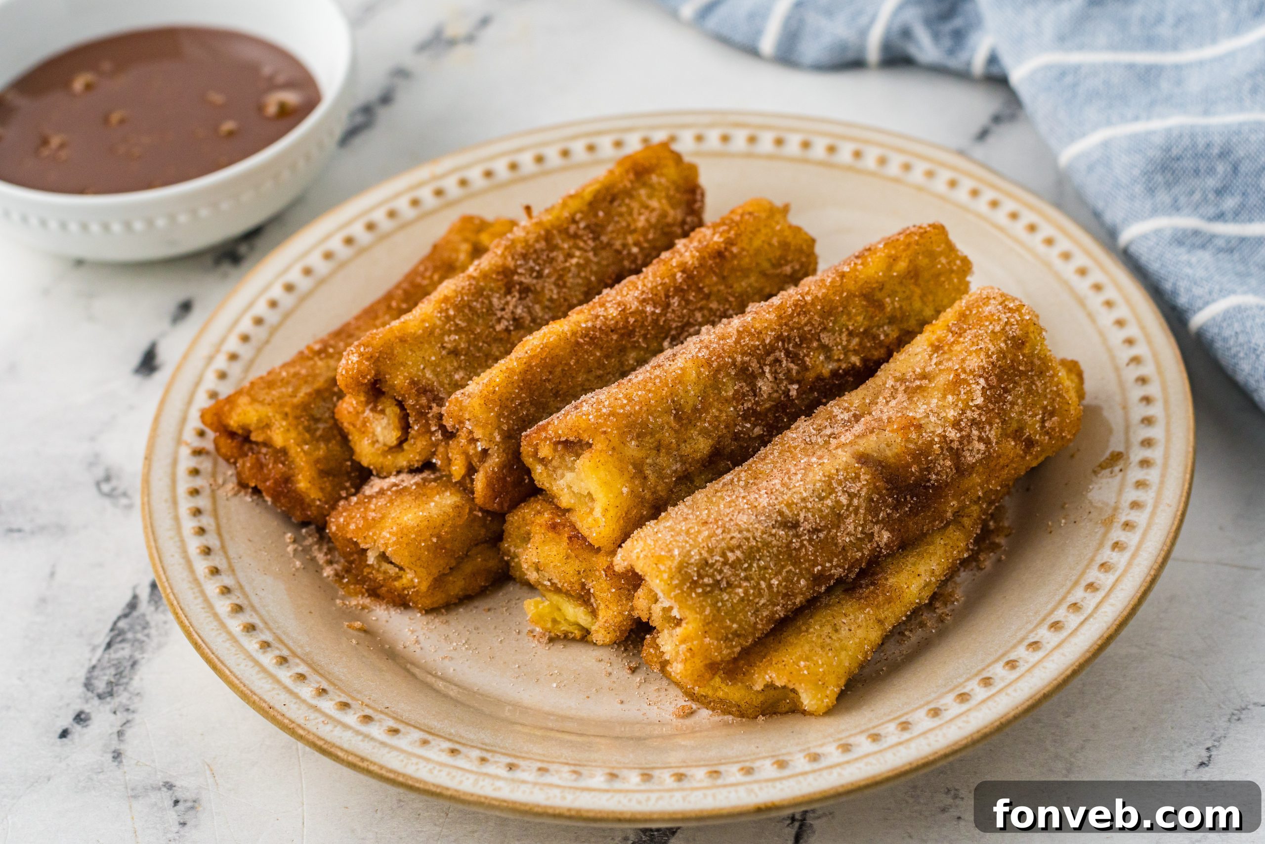 A bowl of cinnamon and sugar mixture, ready for coating the French toast rolls.