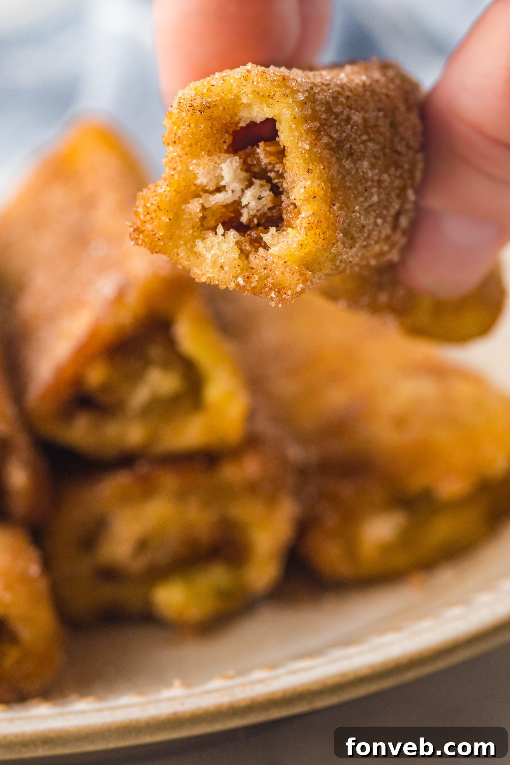 Flattened white bread slices with dulce de leche spread, ready to be rolled up.