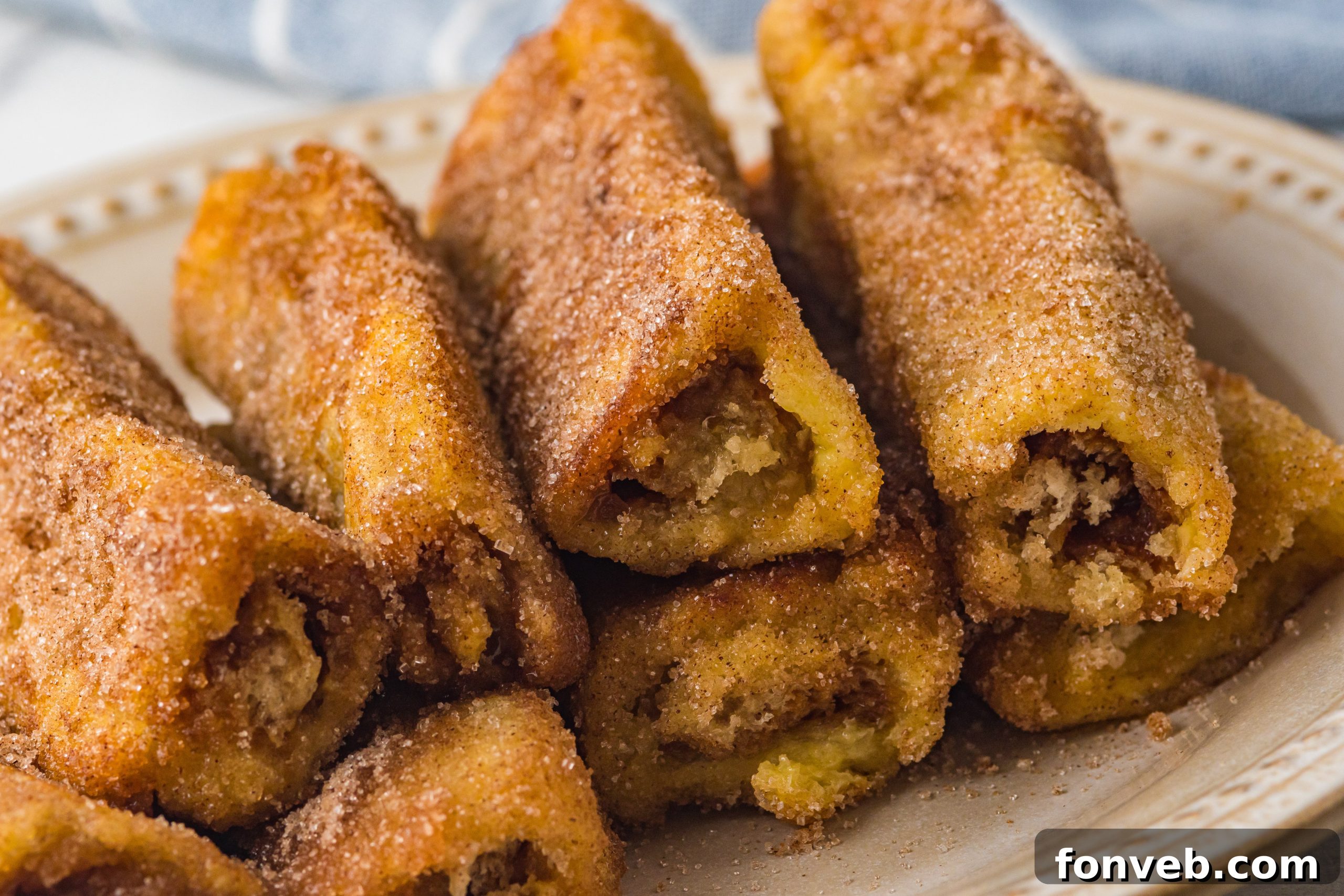 Churro French Toast Roll Ups sizzling in a pan with melted butter, turning golden brown.