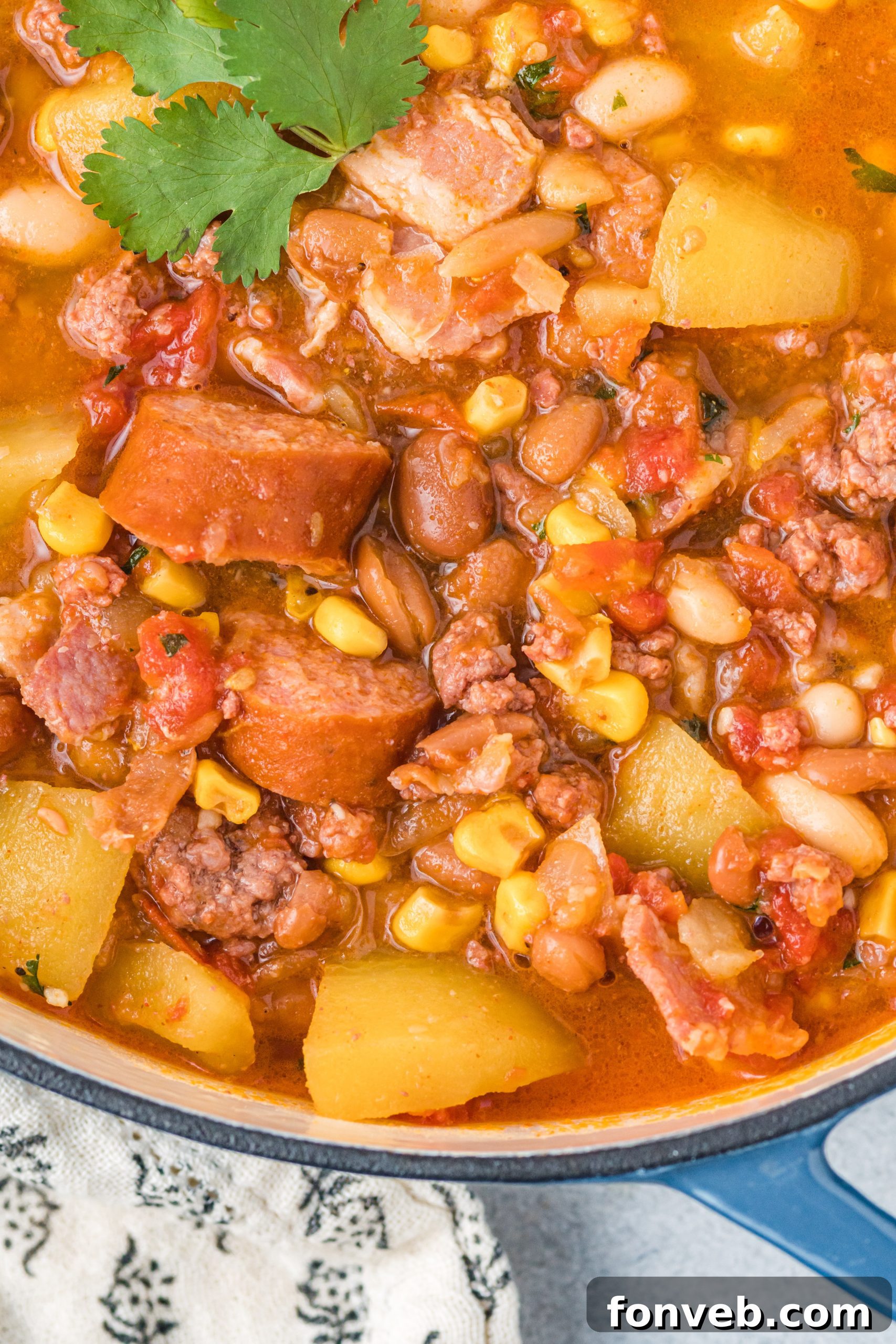 Wrangler's Hearty Stew 4 A large pot of Cowboy Stew simmering on the stove, filled with ingredients like meat, potatoes, and corn.