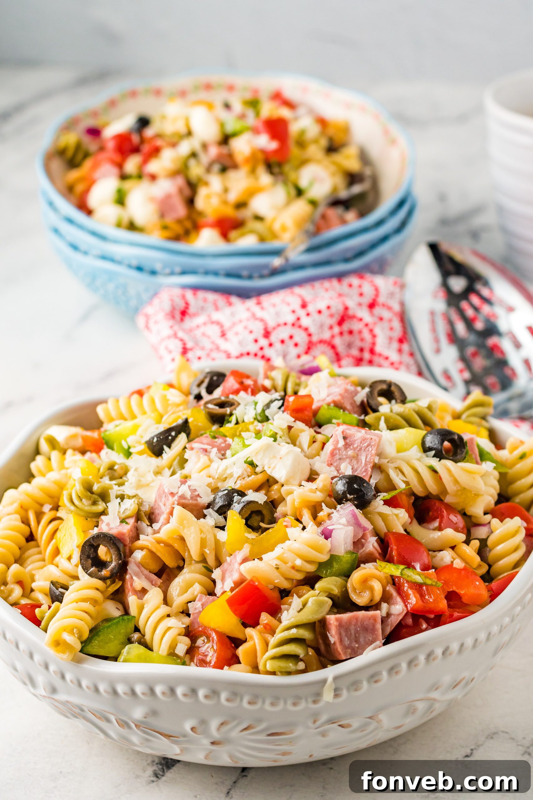 A selection of meats for the pasta salad, including sliced summer sausage and pepperoni, ready for chopping.