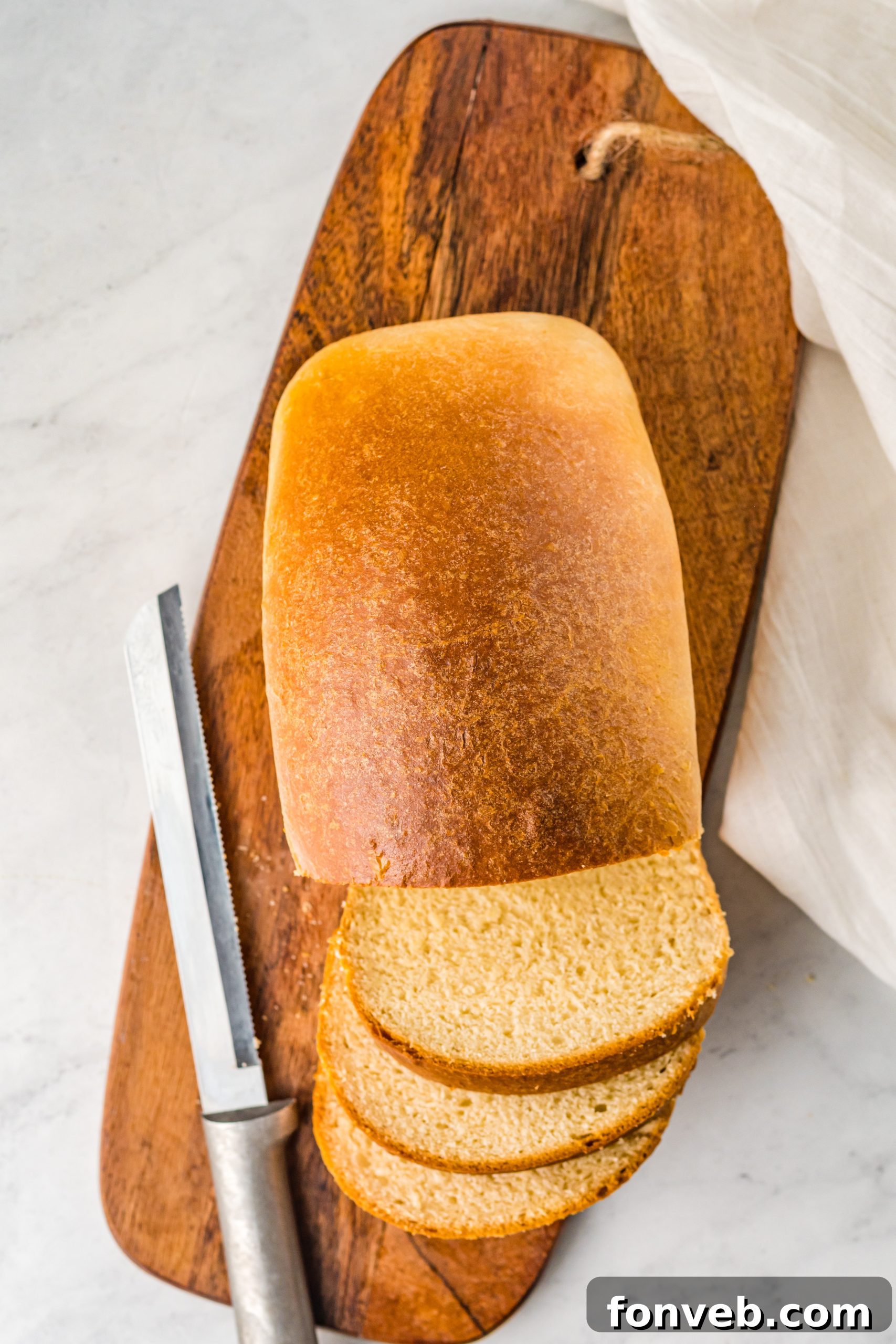 Closeup of bread dough being kneaded in a stand mixer.