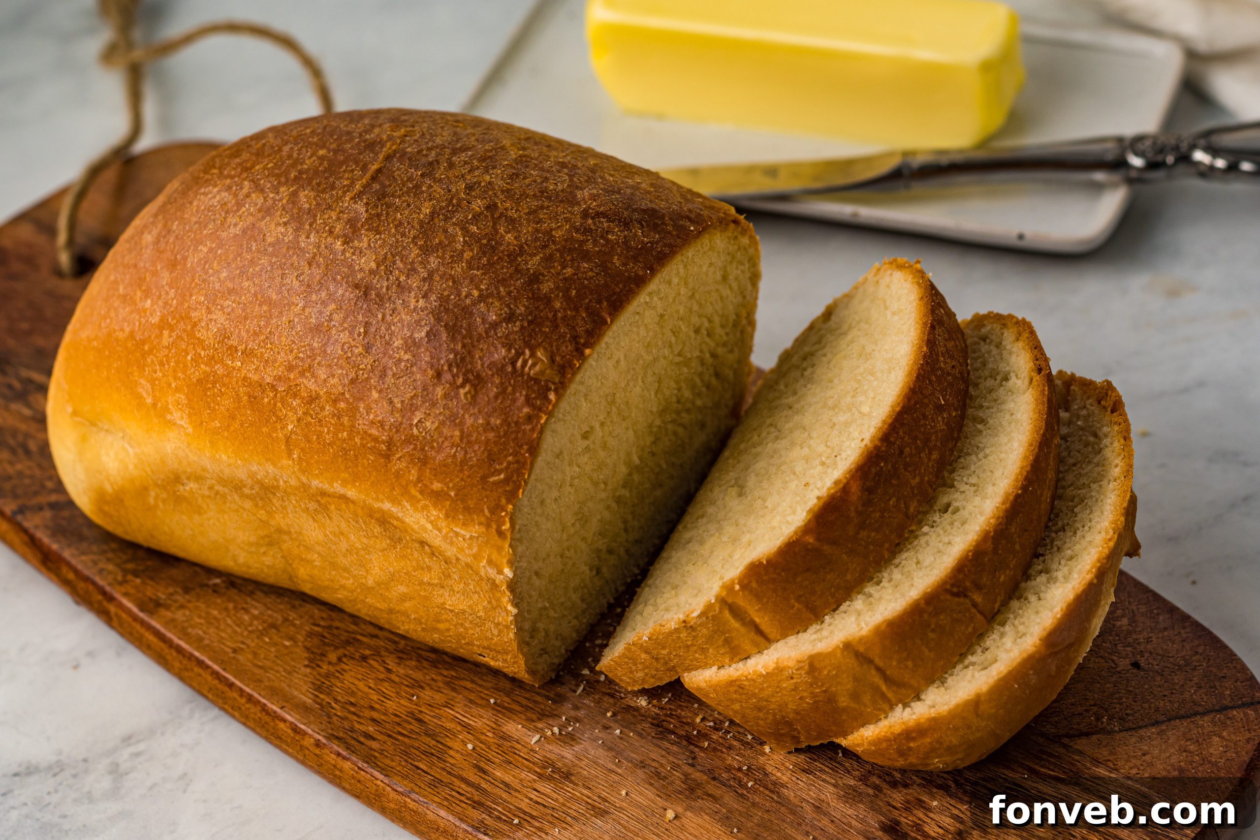 Freshly baked bread with butter on a cutting board.