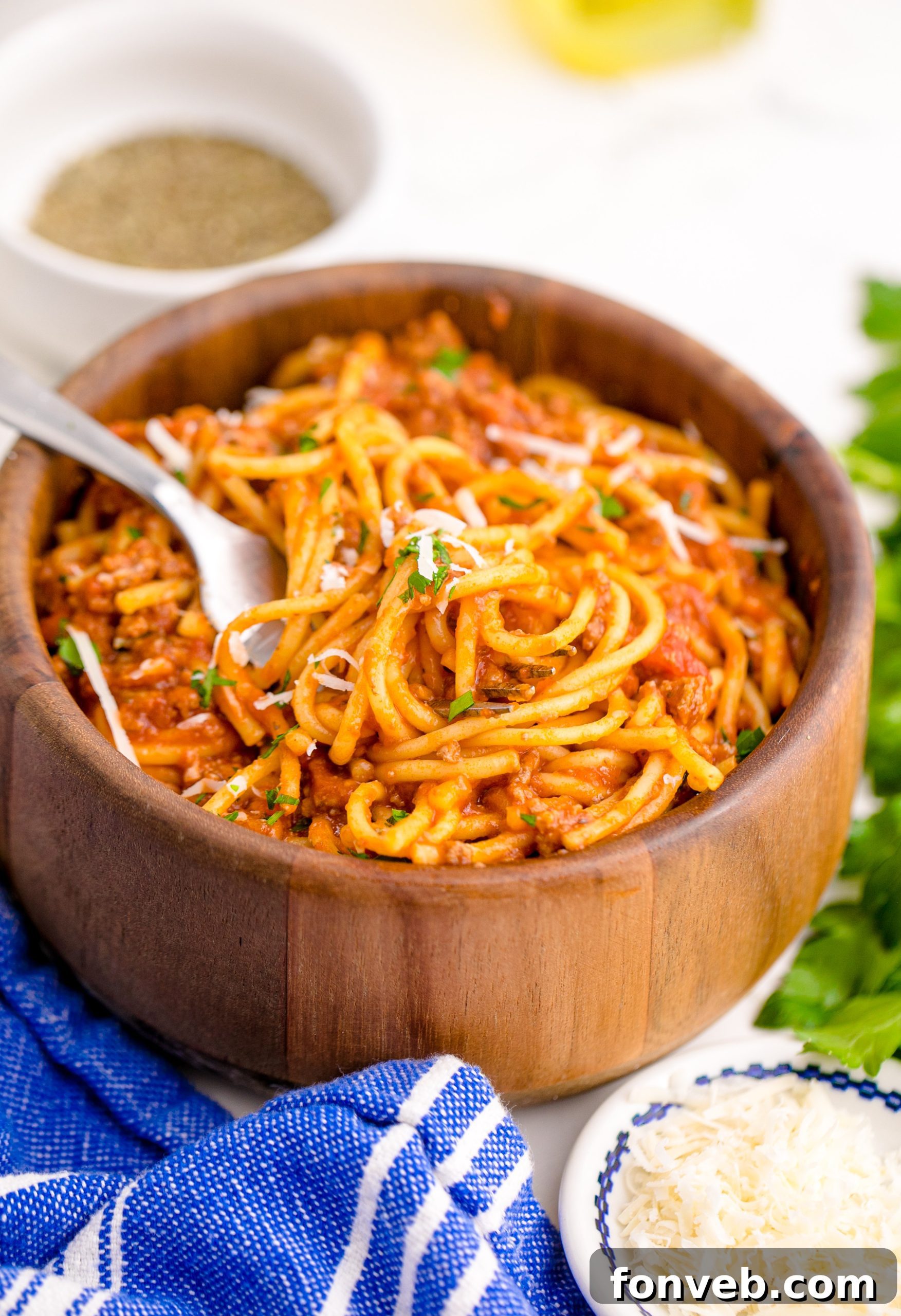 Instant Pot Spaghetti in a wooden bowl with a fork lifting the spaghetti up
