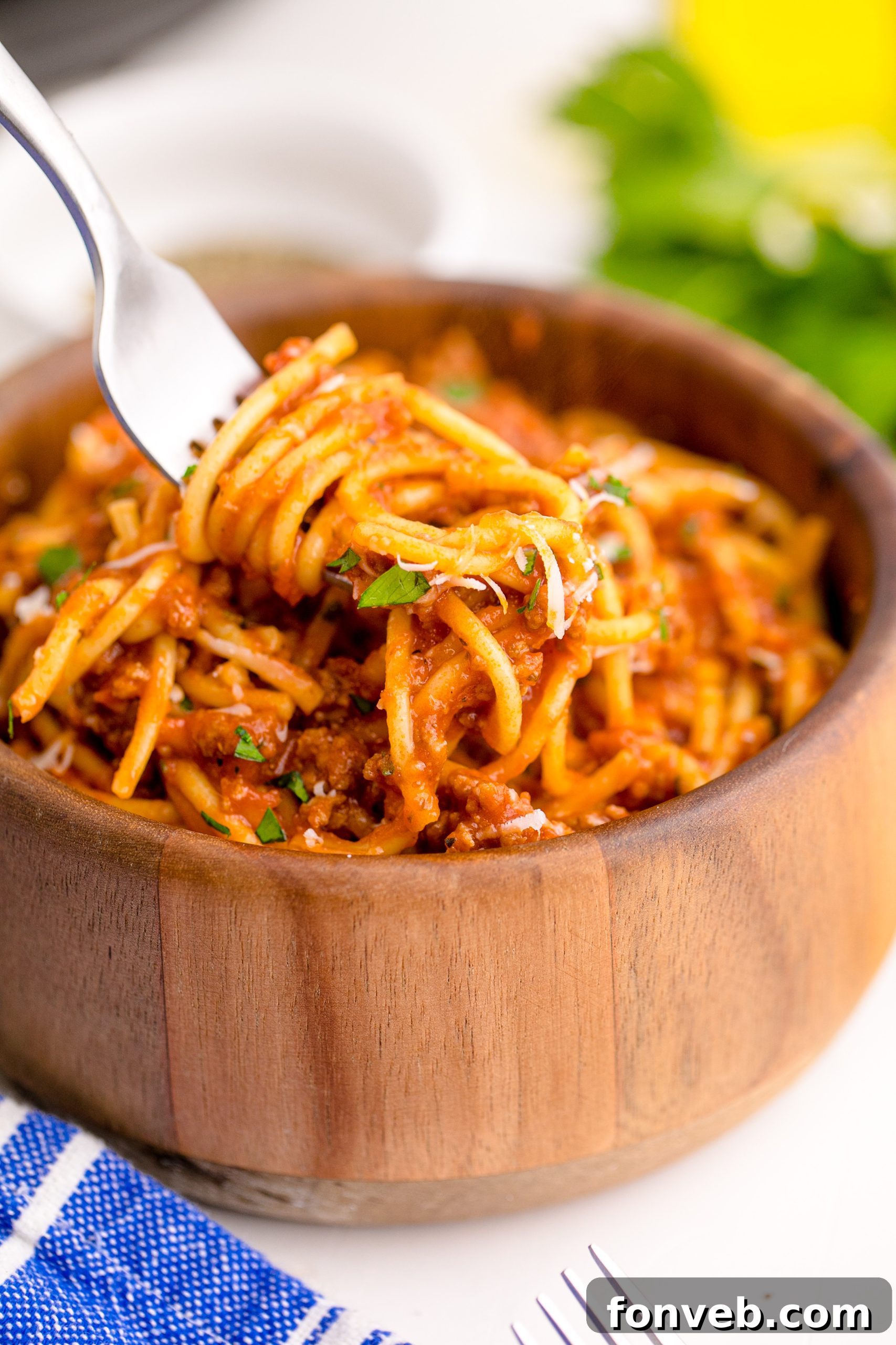 Instant Pot Spaghetti in a wooden bowl with a fork lifting the spaghetti up