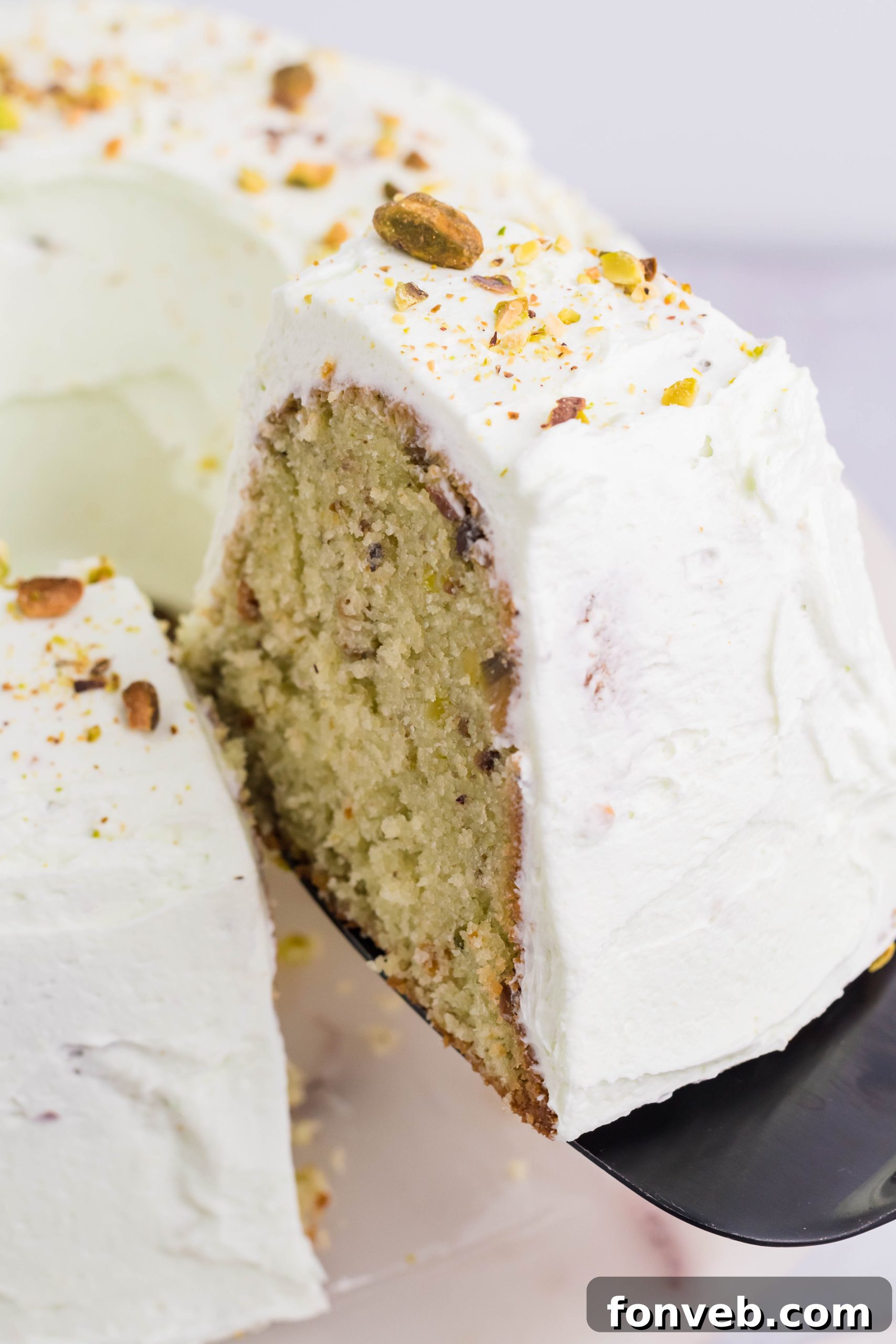 Pistachio Cake slice being lifted on a spatula