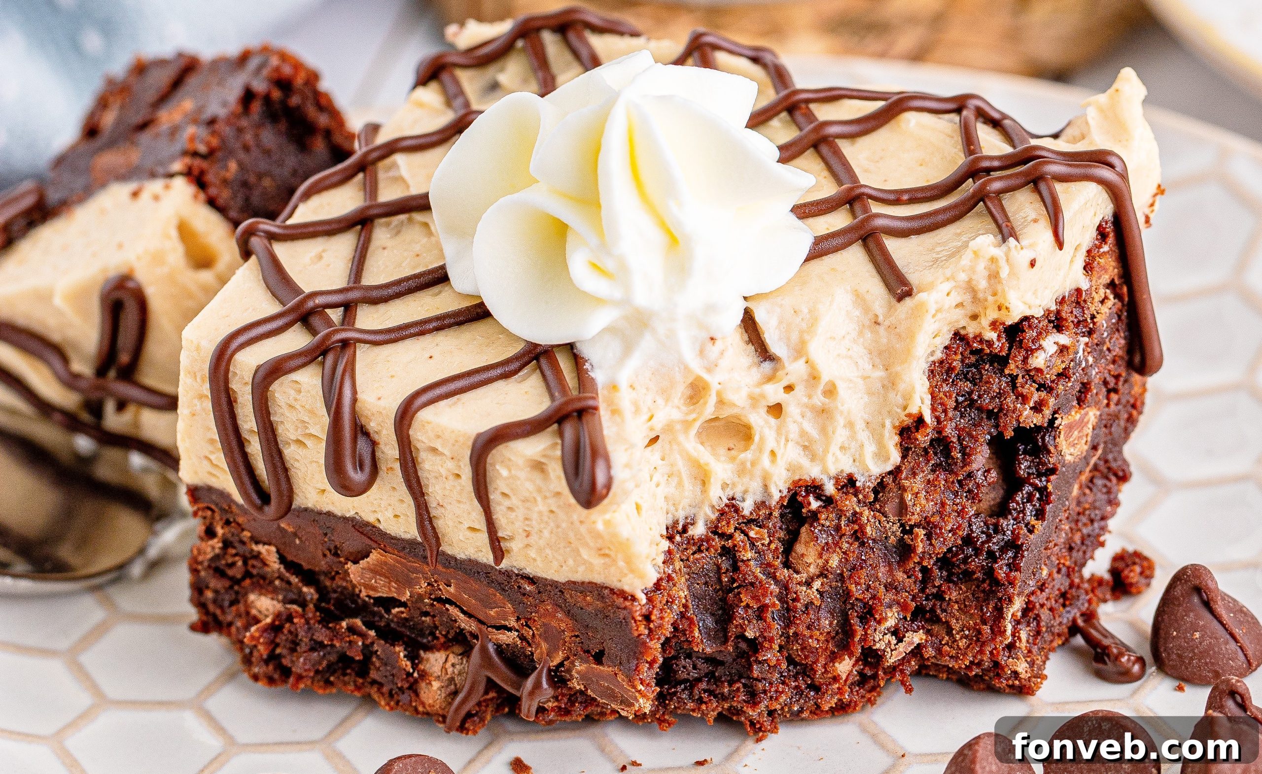 Peanut Butter Brownies on a white place drizzeled with chocolate and topped with whipped cream