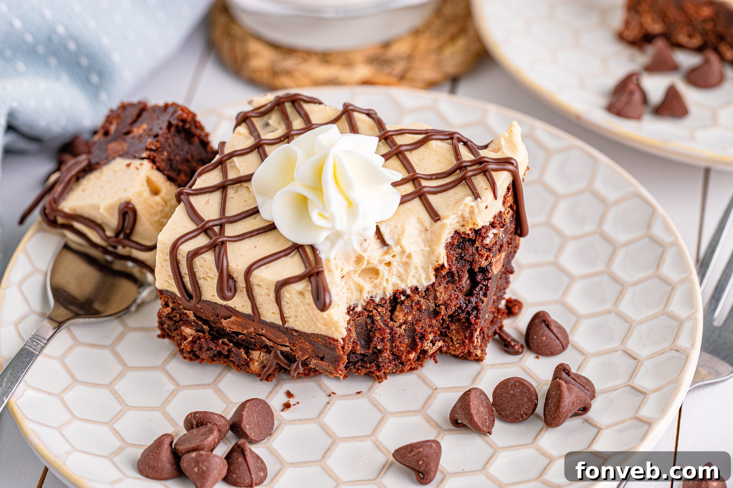 Peanut Butter Brownies on a white place drizzeled with chocolate and topped with whipped cream