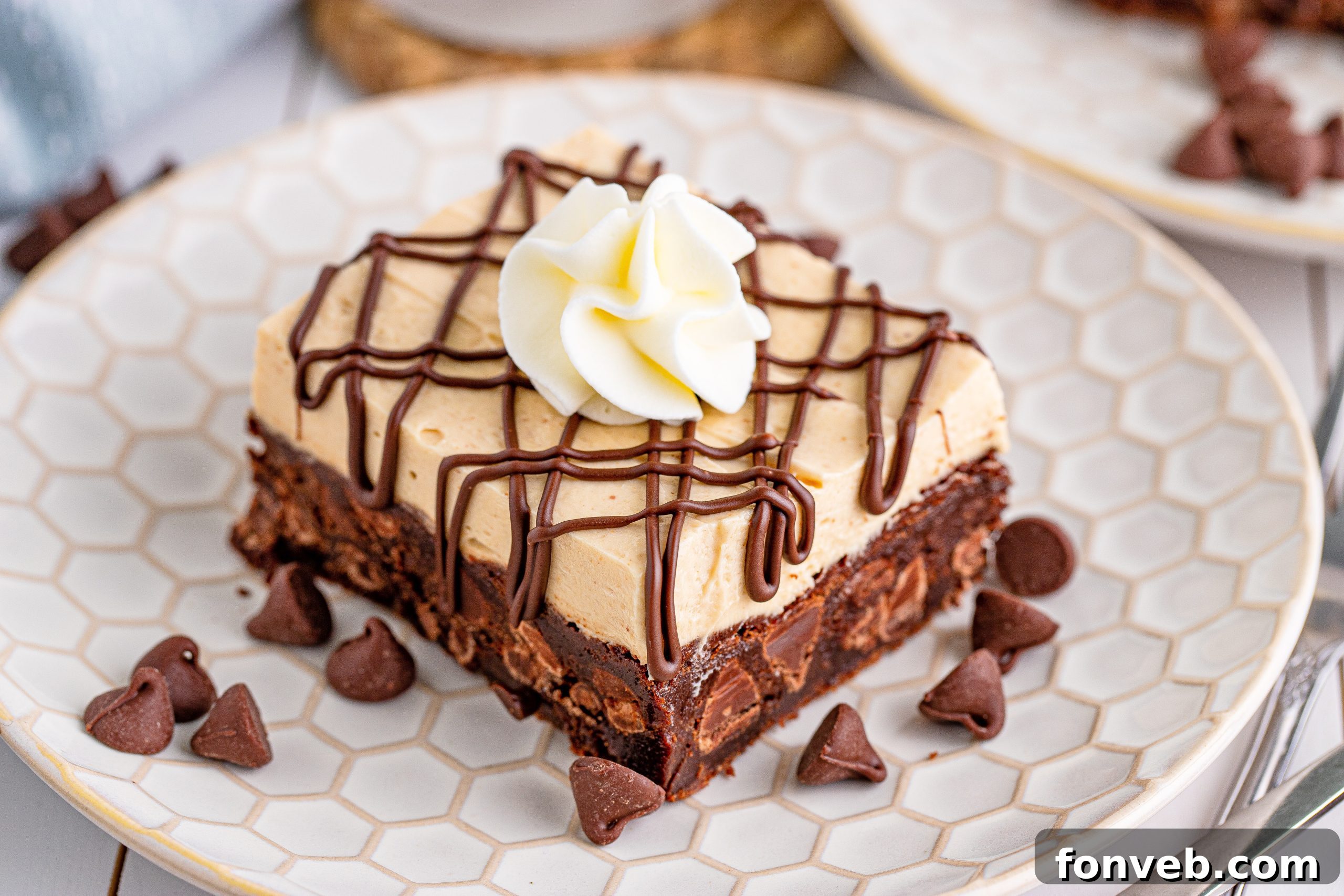 Peanut Butter Brownies on a white place drizzled with chocolate and topped with whipped cream