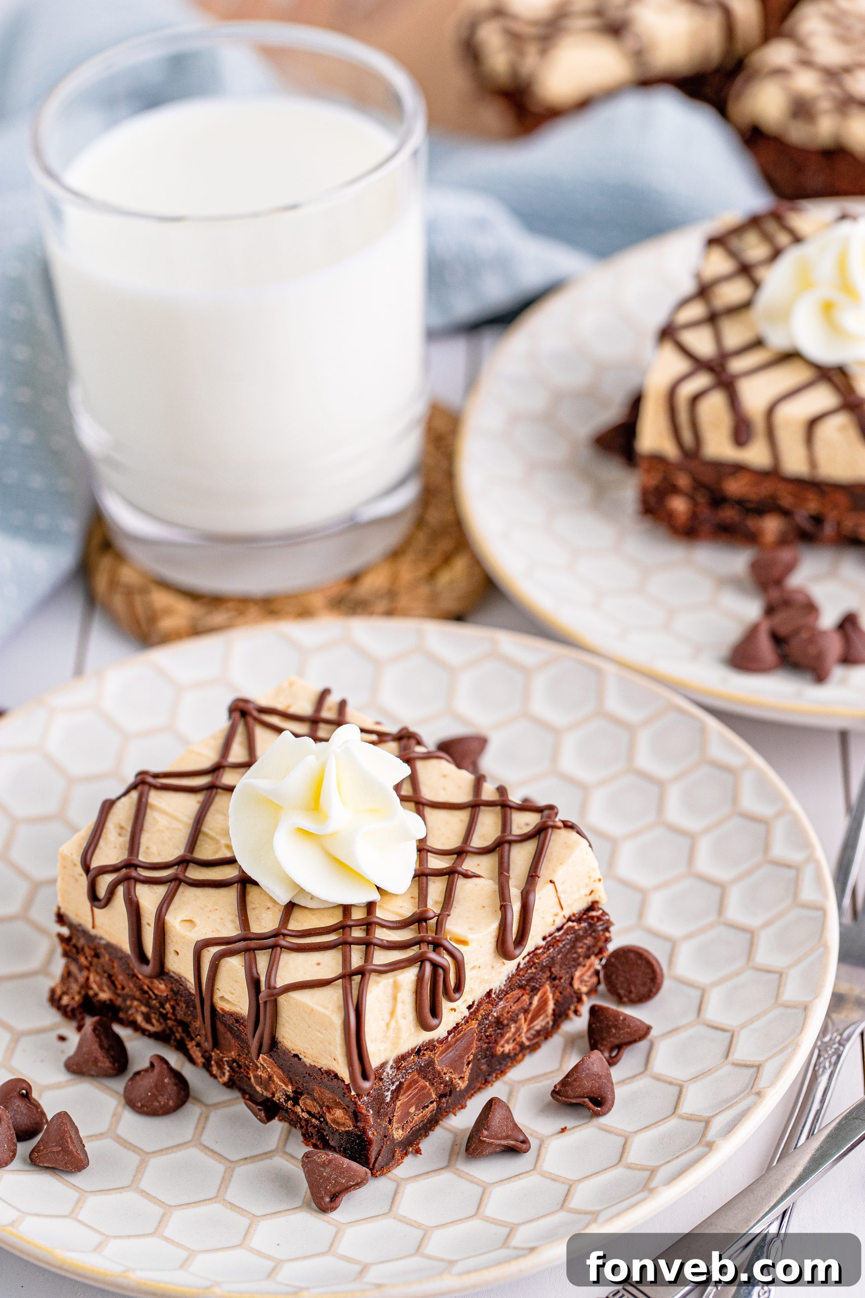 Peanut Butter Brownies on a white place drizzled with chocolate and topped with whipped cream