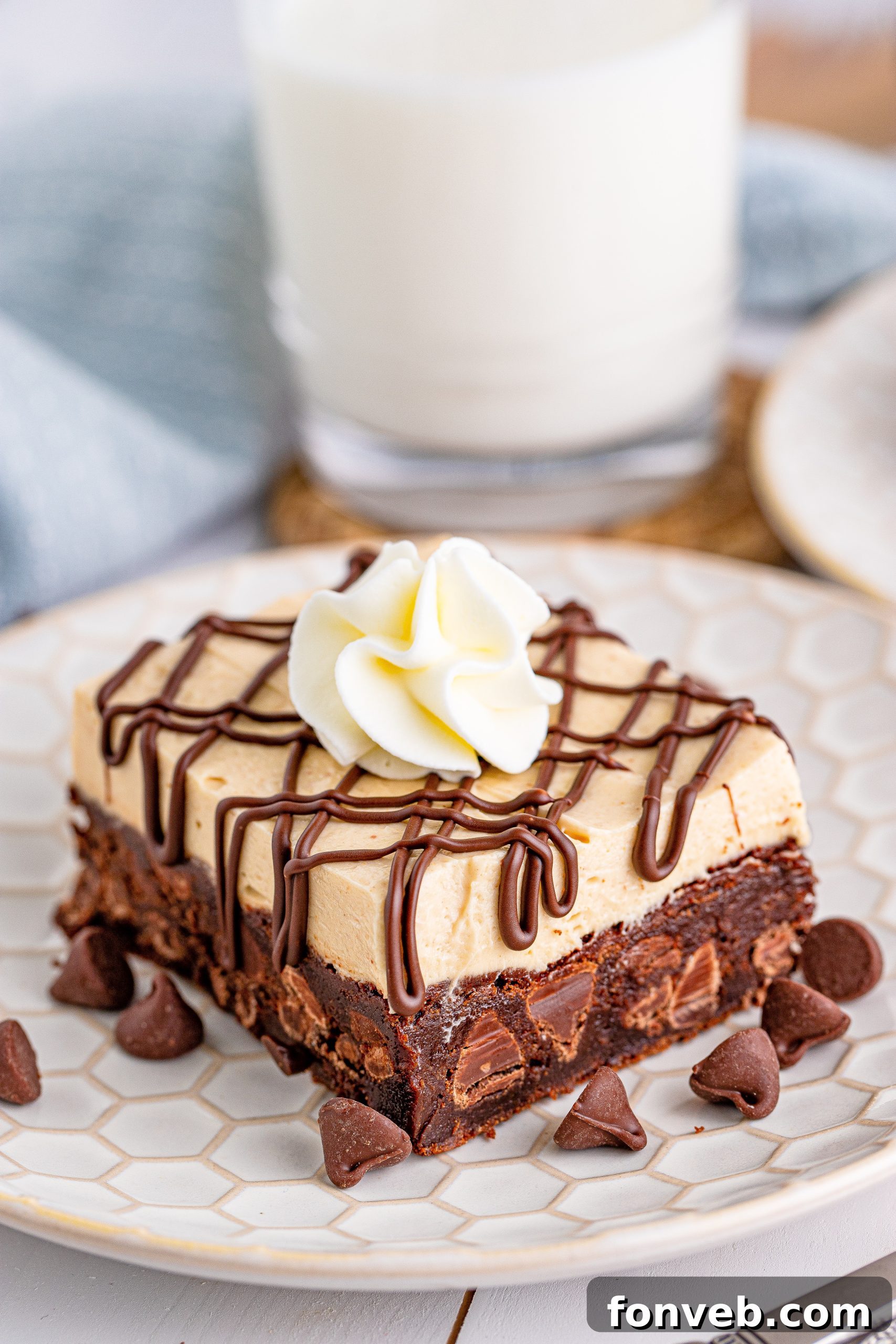 Peanut Butter Brownies on a white place drizzled with chocolate and topped with whipped cream
