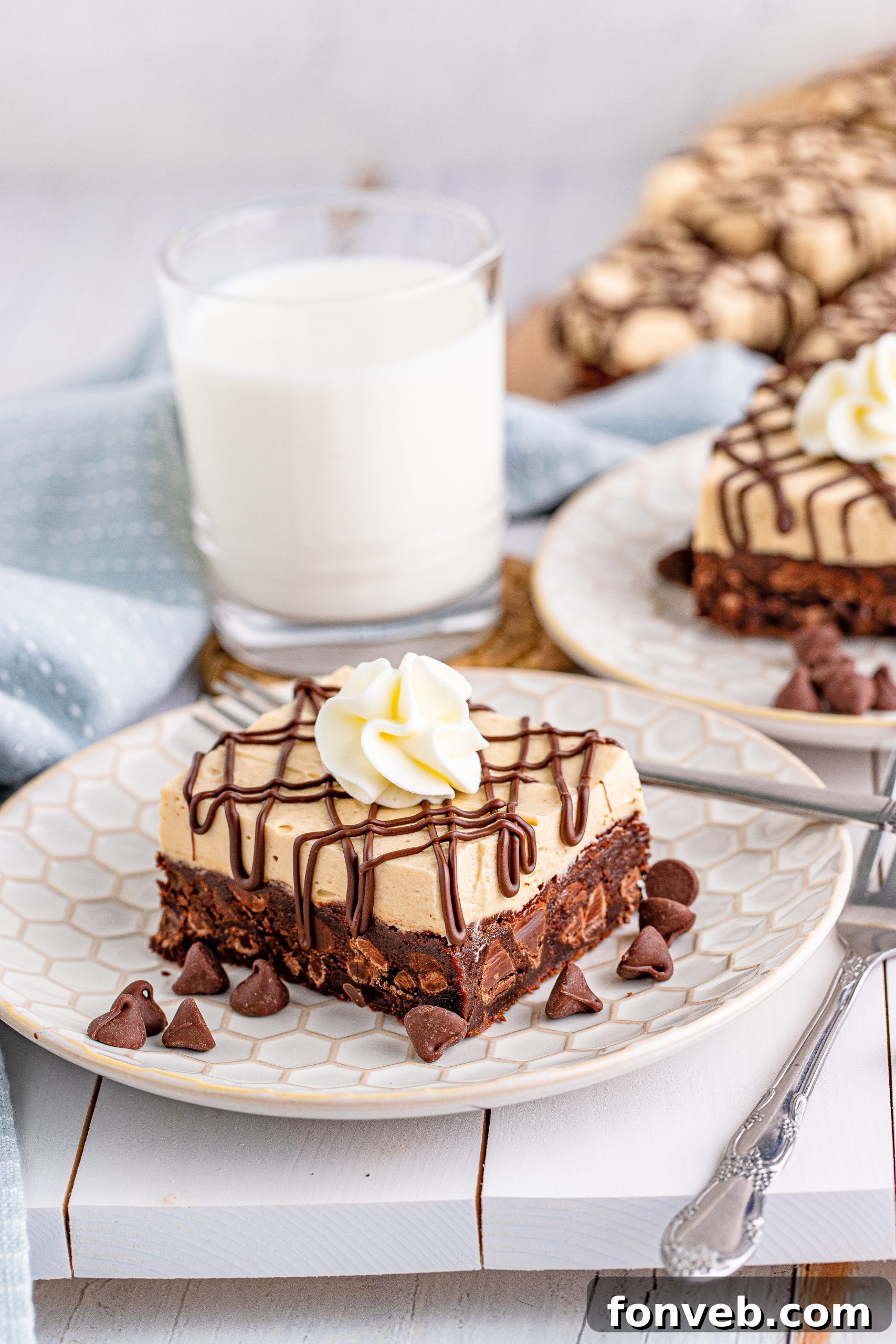 Peanut Butter Brownies on a white place drizzeled with chocolate and topped with whipped cream