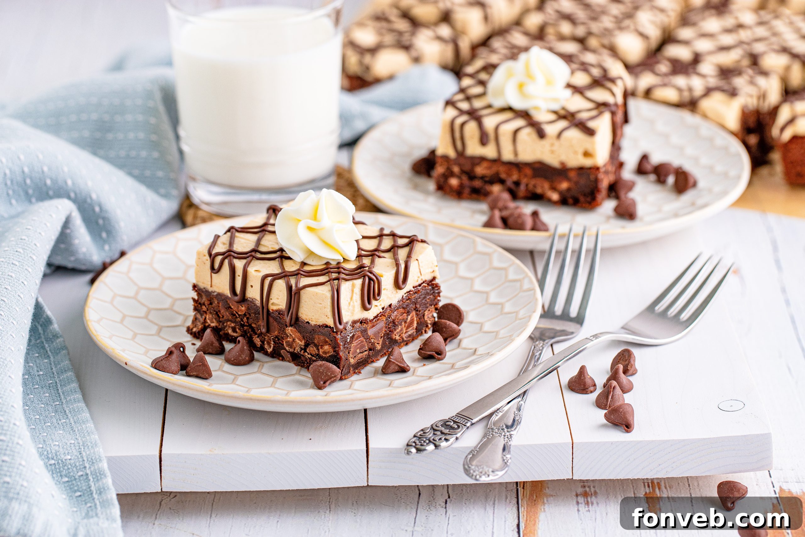 Peanut Butter Brownies on a white place drizzeled with chocolate and topped with whipped cream with a cup of milk