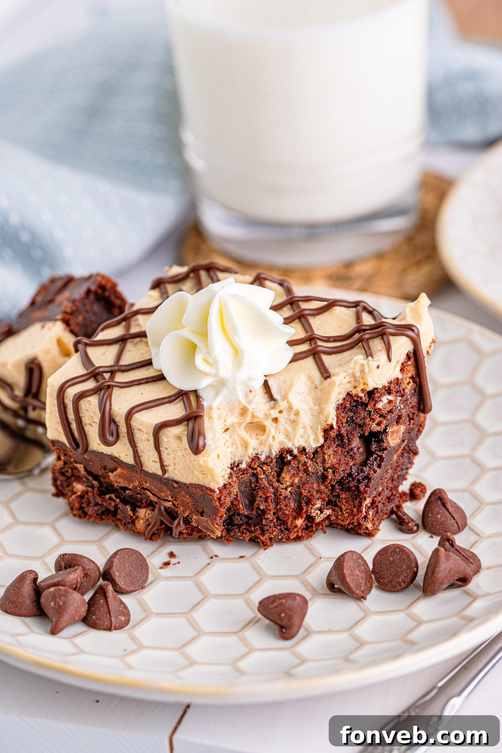 Peanut Butter Brownies on a white place drizzeled with chocolate and topped with whipped cream