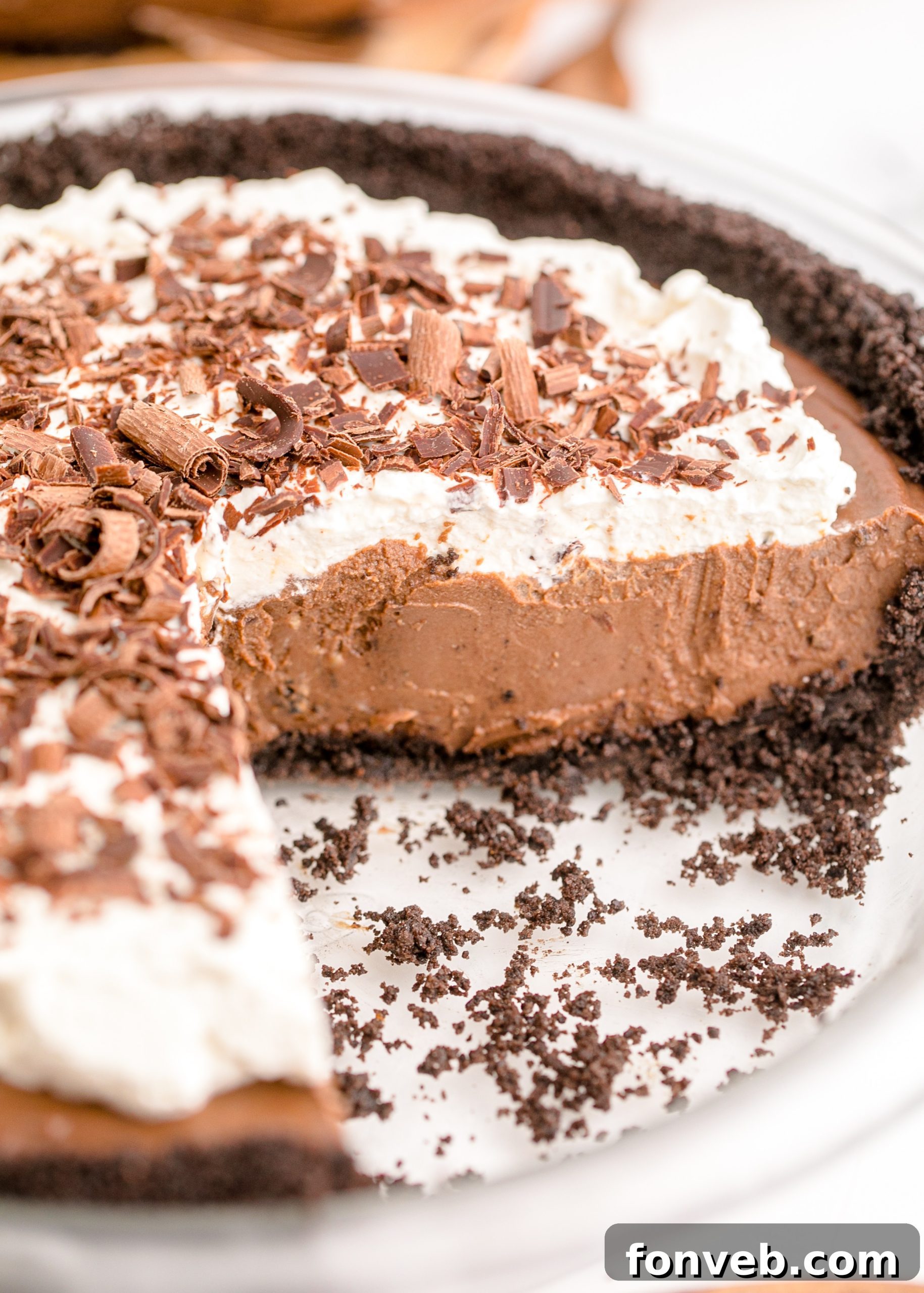 Velvet Chocolate Dream 2 Chocolate Cream Pie topped with whipped cream and chocolate shavings on a white pie dish with a slice cut out