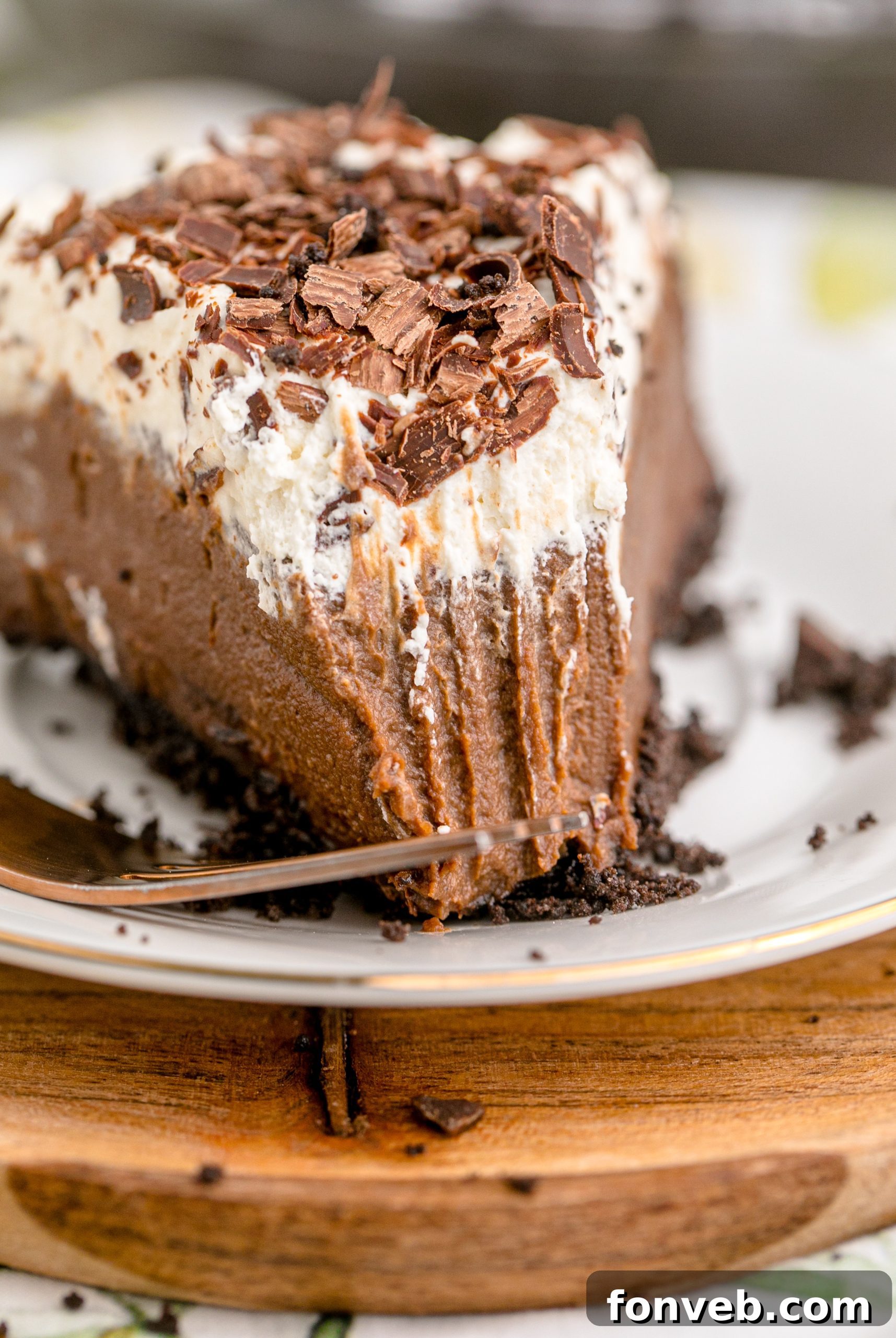 Velvet Chocolate Dream 16 Chocolate Cream Pie topped with whipped cream and chocolate shavings on a white plate, close-up