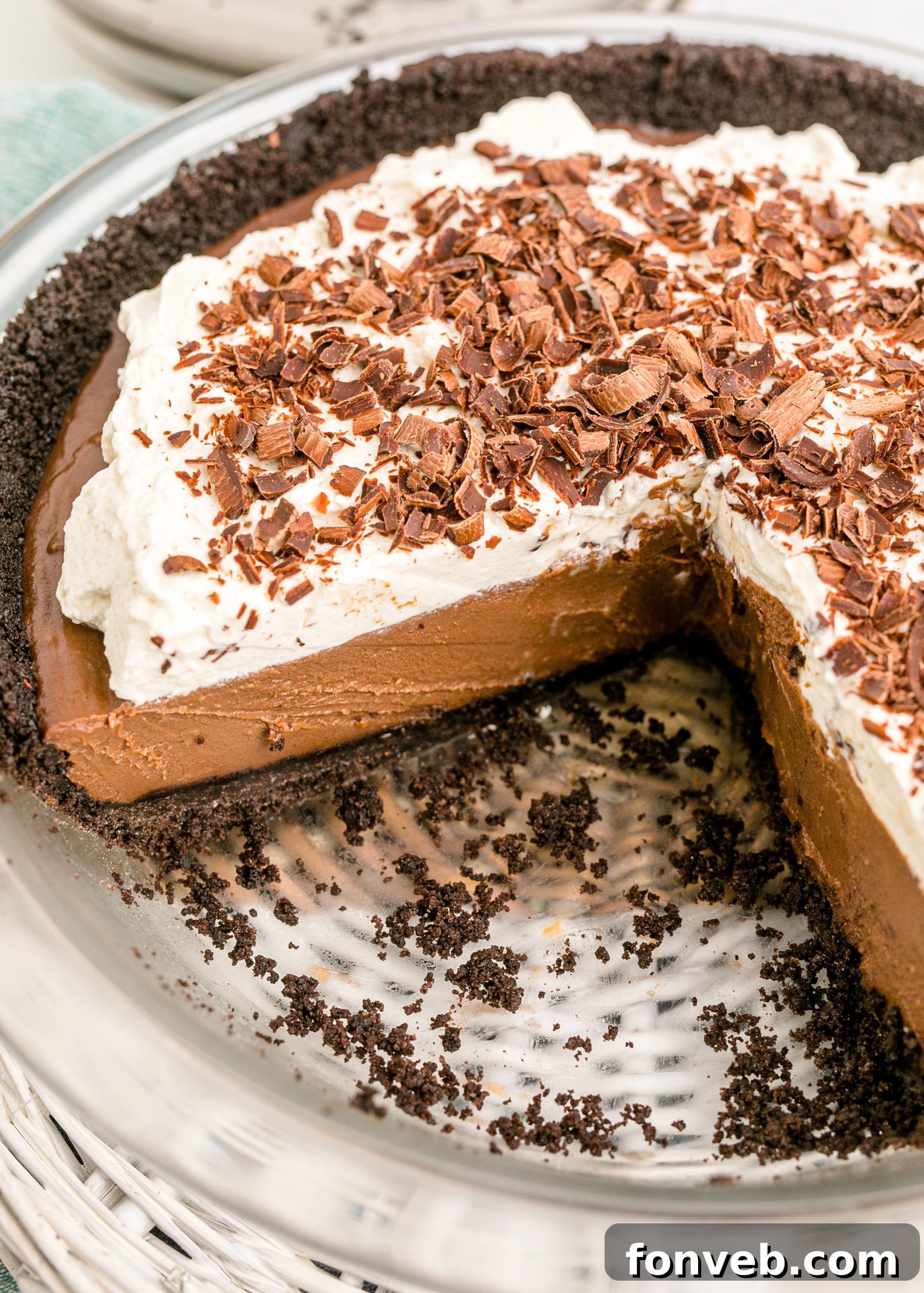 Velvet Chocolate Dream 17 Chocolate Cream Pie topped with whipped cream and chocolate shavings in a white pie dish with a slice taken out