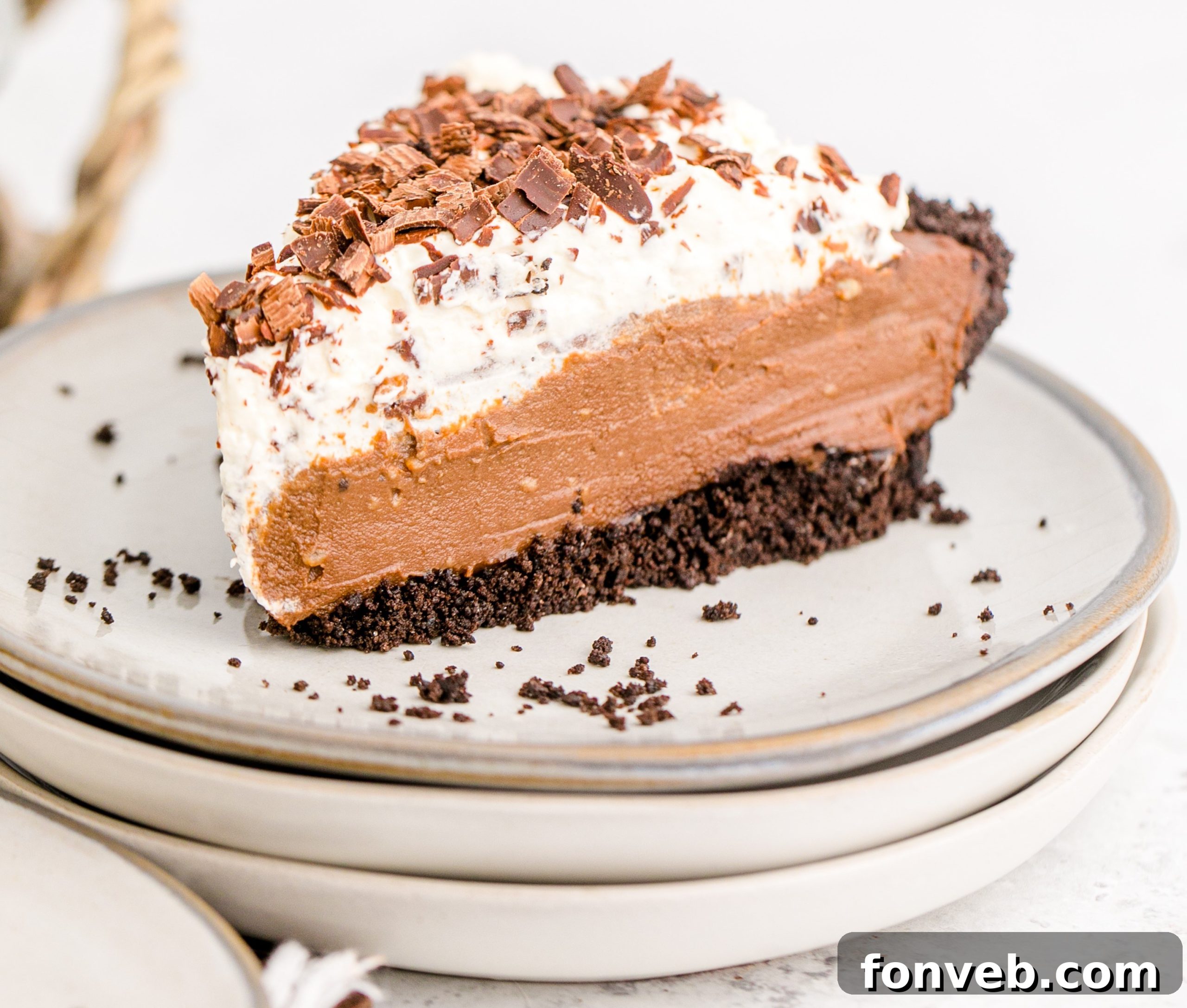 Velvet Chocolate Dream 20 Chocolate Cream Pie topped with whipped cream and chocolate shavings on a white plate