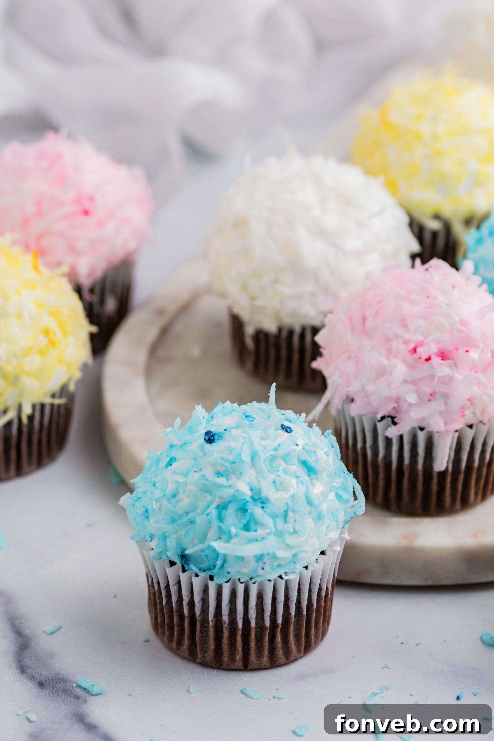 Pink, yellow, white, and blue chocolate cupcakes topped with coconut