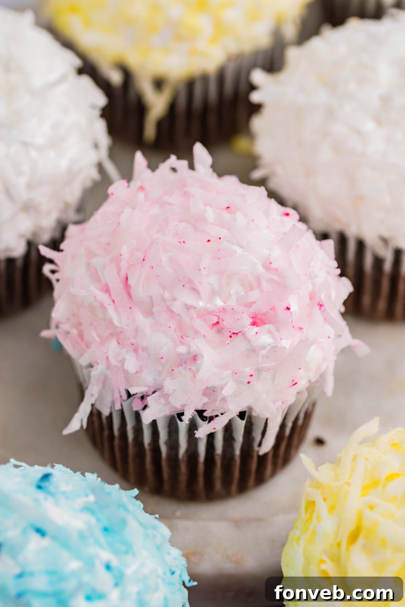Chocolate cupcake with pink coconut shavings & marshmallow frosting on a marble platter