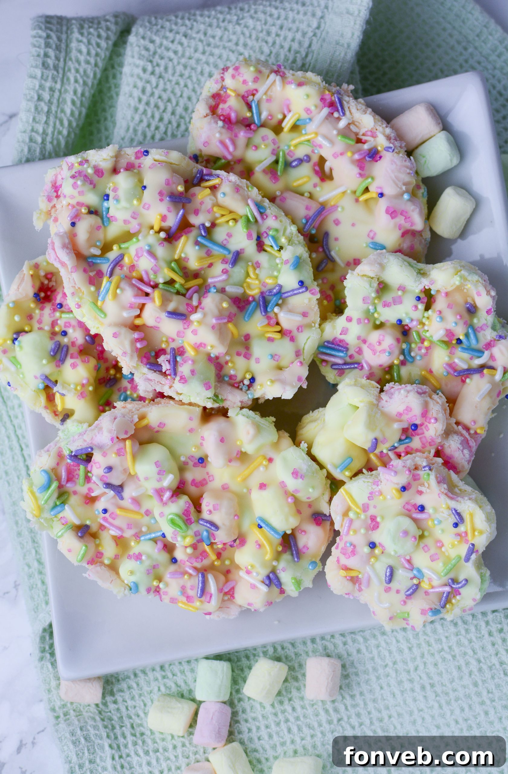 Easter Marshmallow treats with pink, green and yellow mini marshmallows cut into the shape of eggs on a white plate