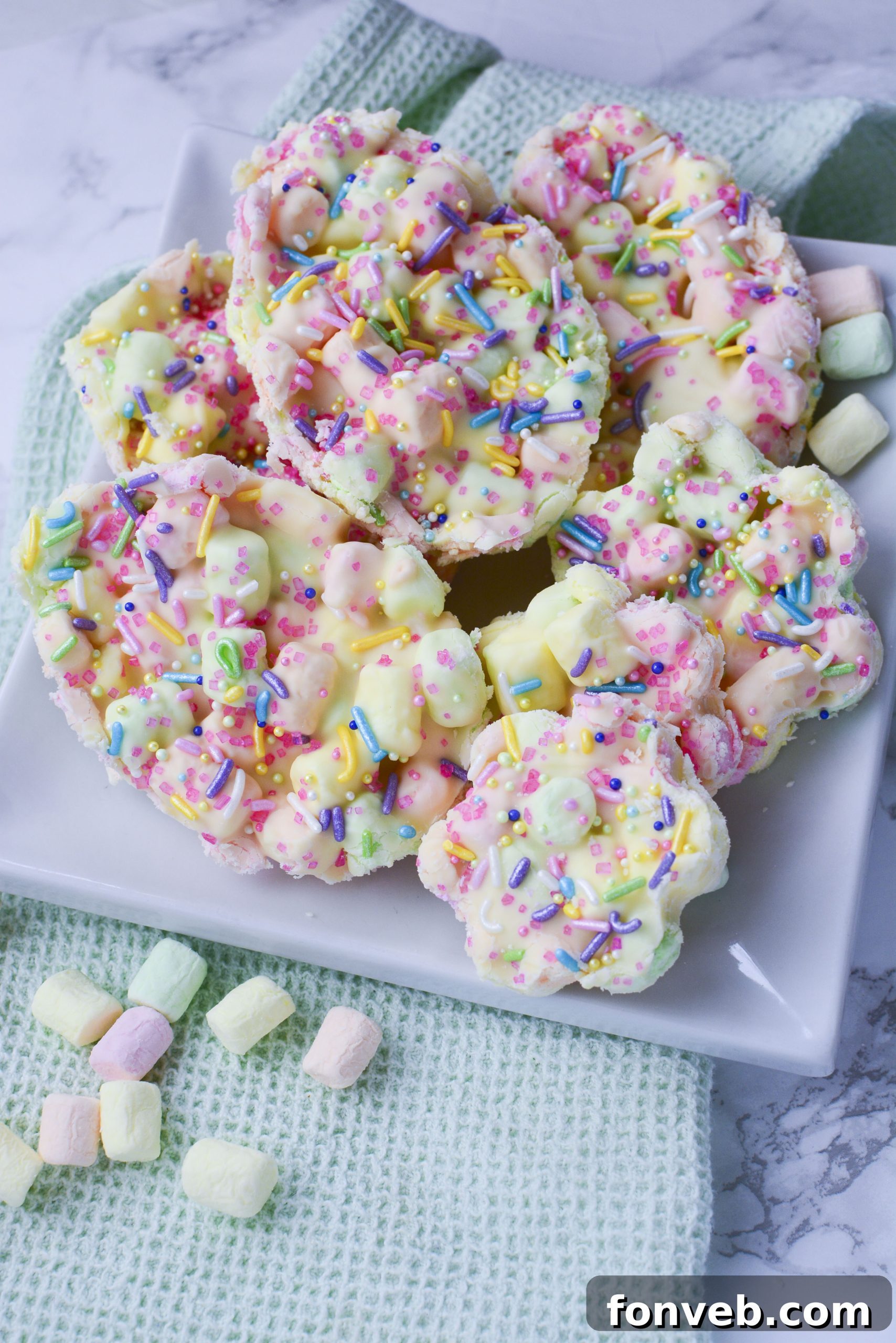 Easter Marshmallow treats with pink, green and yellow mini marshmallows cut into the shape of eggs and flowers