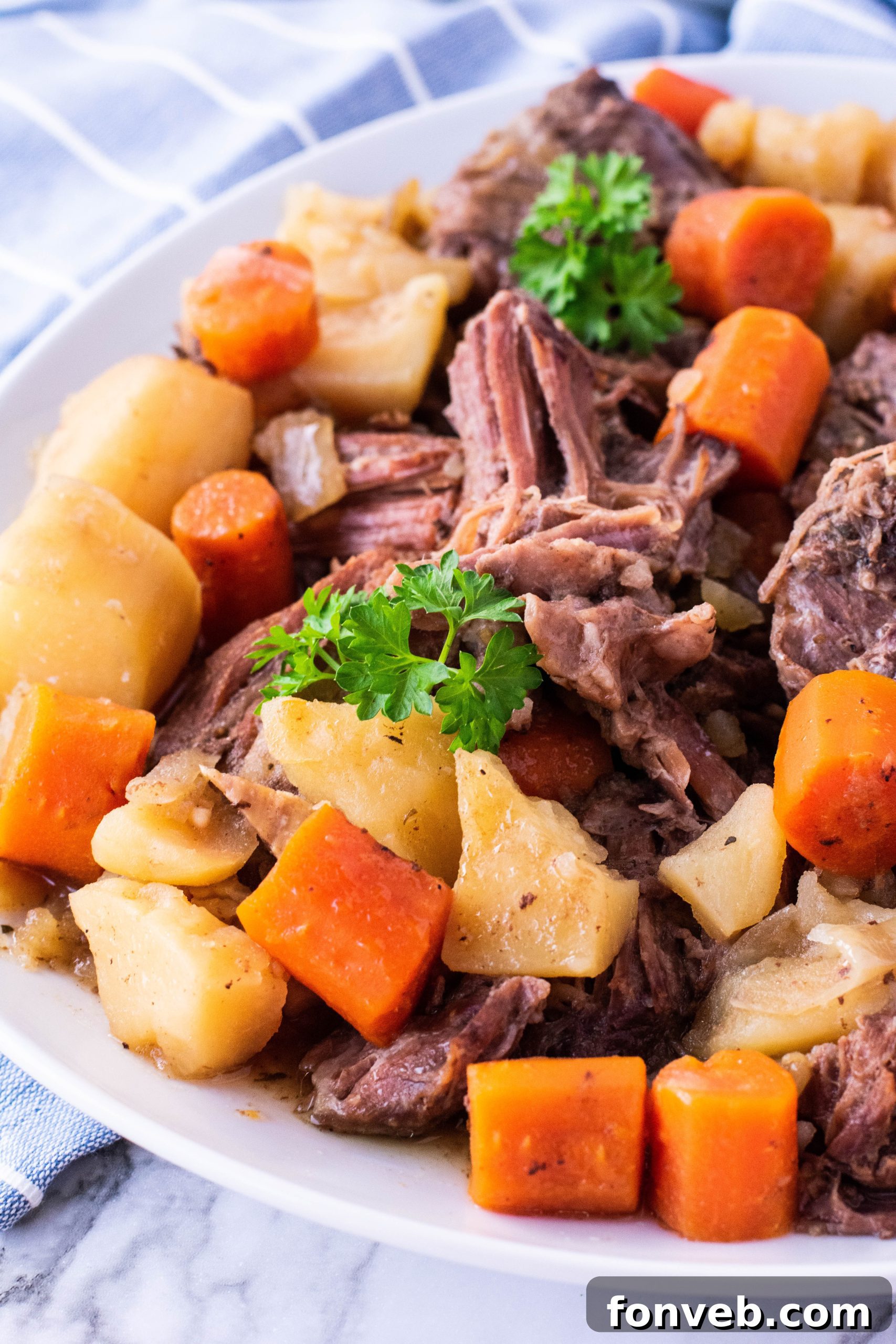 crock pot chuck roast on a plate with potatoes and carrots