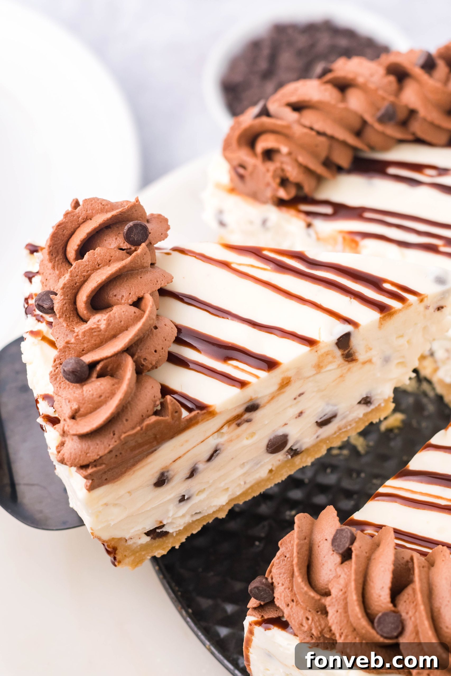Chocolate Chip Cheesecake in a baking pan with a slice being lifted out on a black spatula