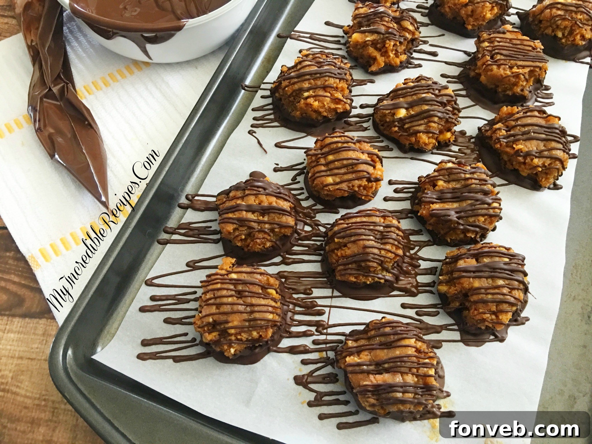 Samoa Bites, fully coated in dark chocolate and elegantly drizzled with additional chocolate, arranged on a parchment paper-lined baking sheet.