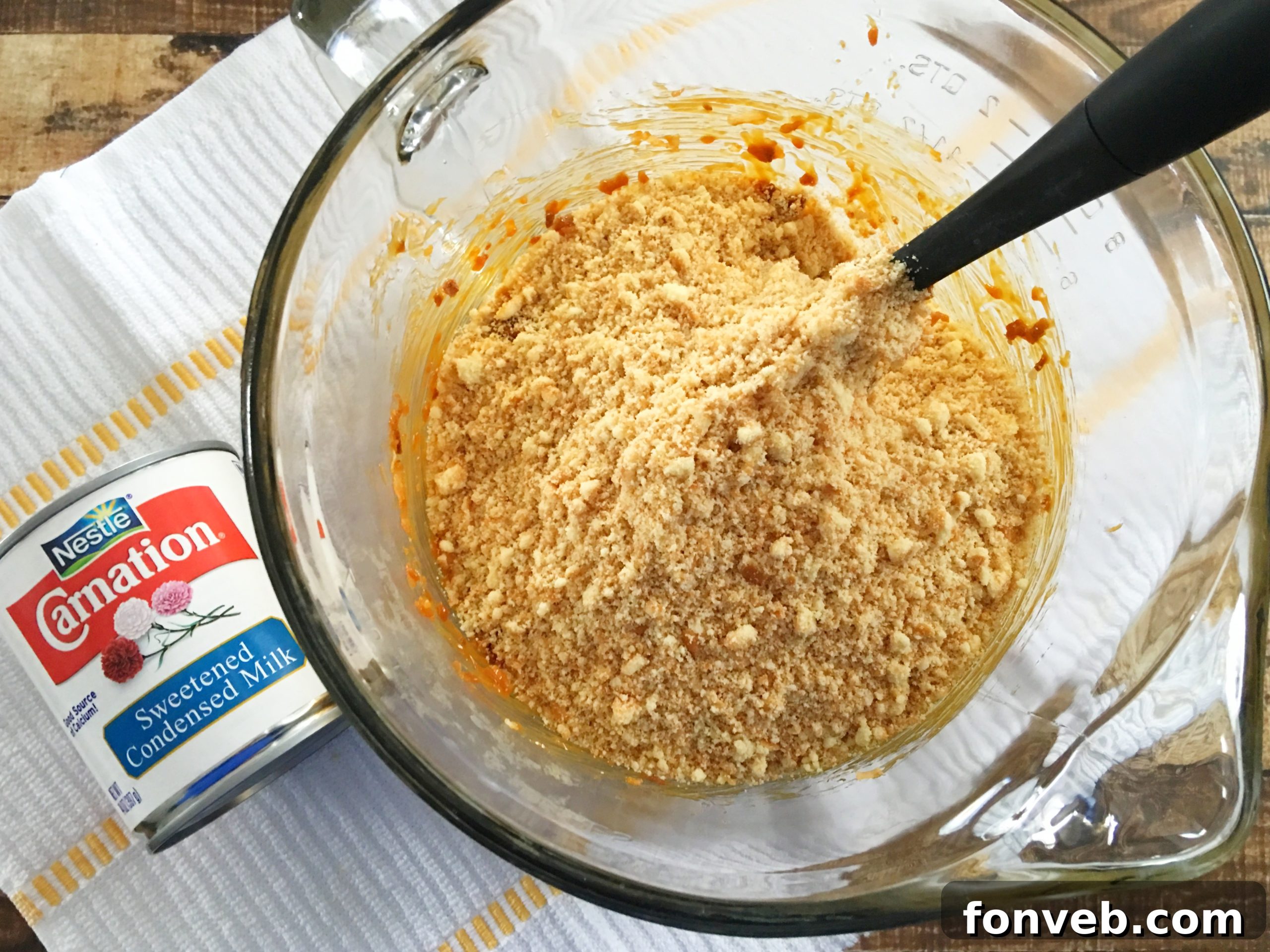 A mixing bowl filled with the base mixture for Samoa Bites, showcasing the crushed Nilla wafers and toasted coconut, ready for the next ingredient.