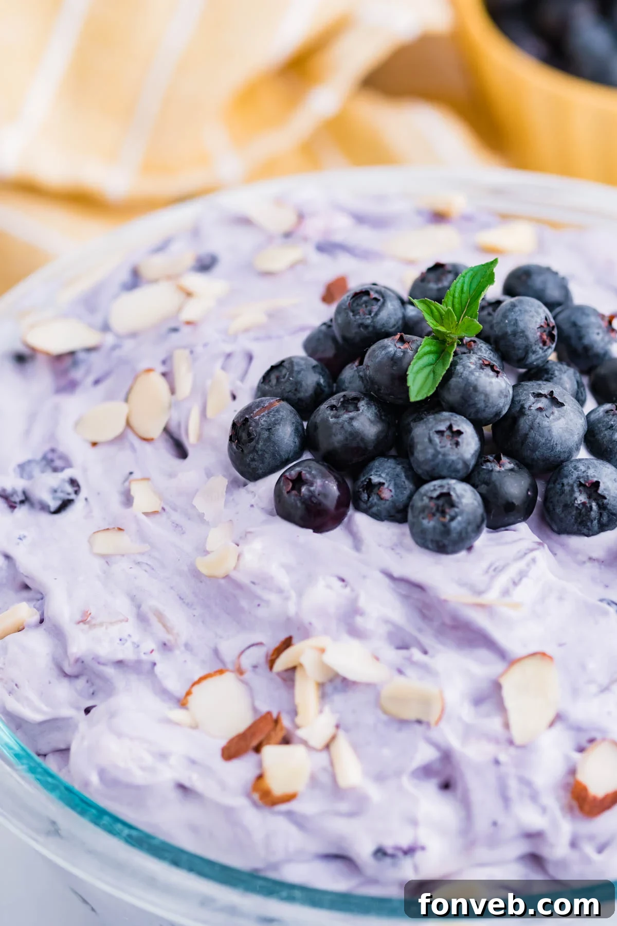 Blueberry Fluff Salad in a clear glass serving bowl close up of the fresh blueberries on top
