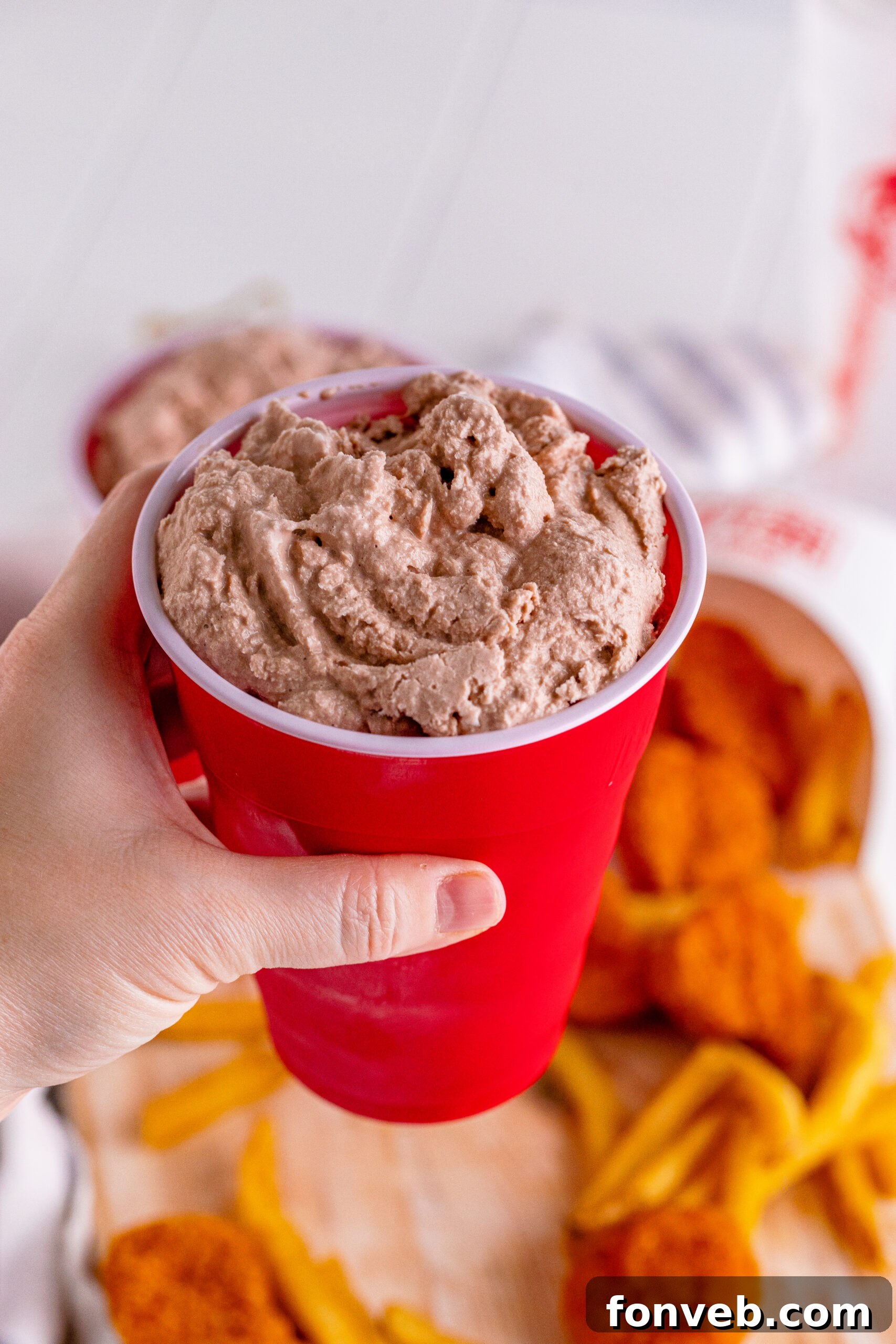 Homemade Wendy's Frosty in a red solo cup, held up, showcasing its perfect consistency