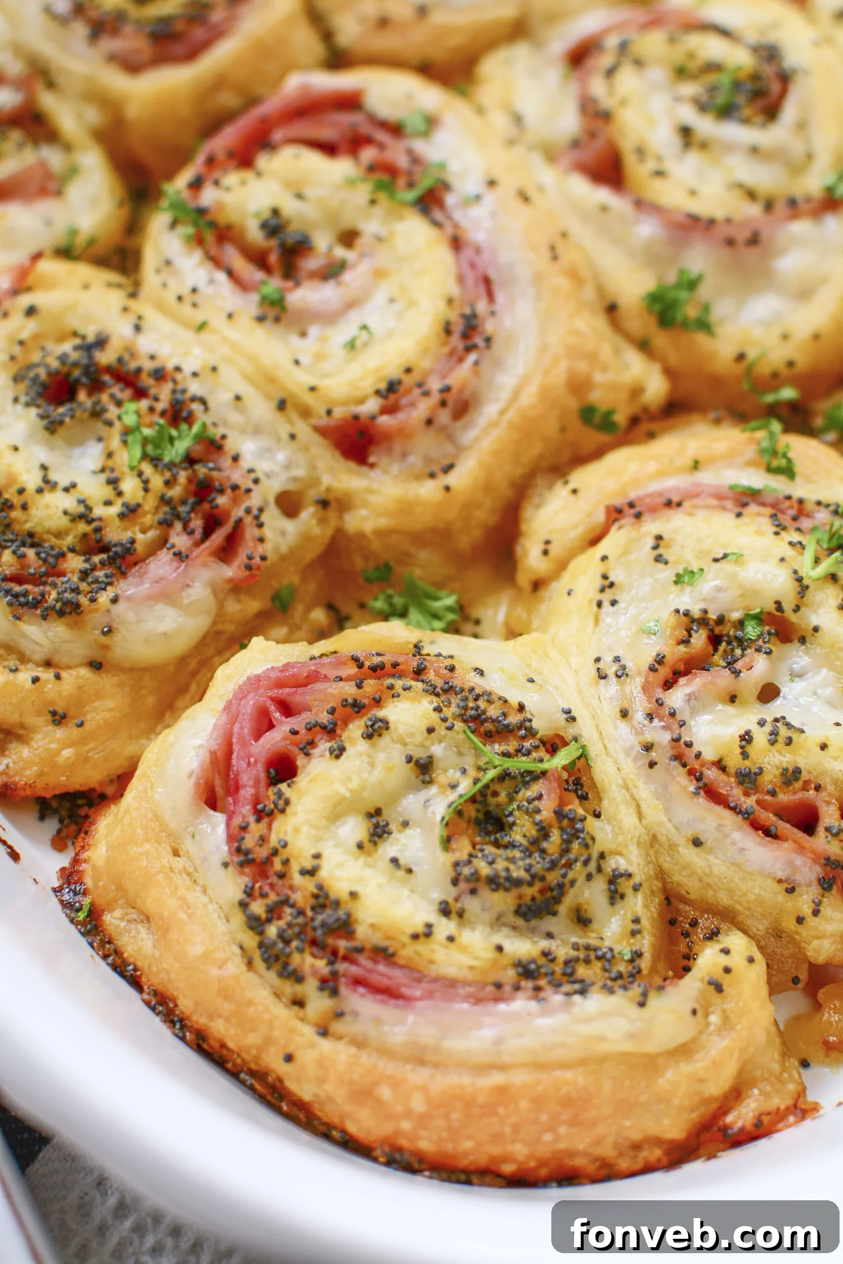 Ham and Cheese Pinwheels in a white baking dish side shot