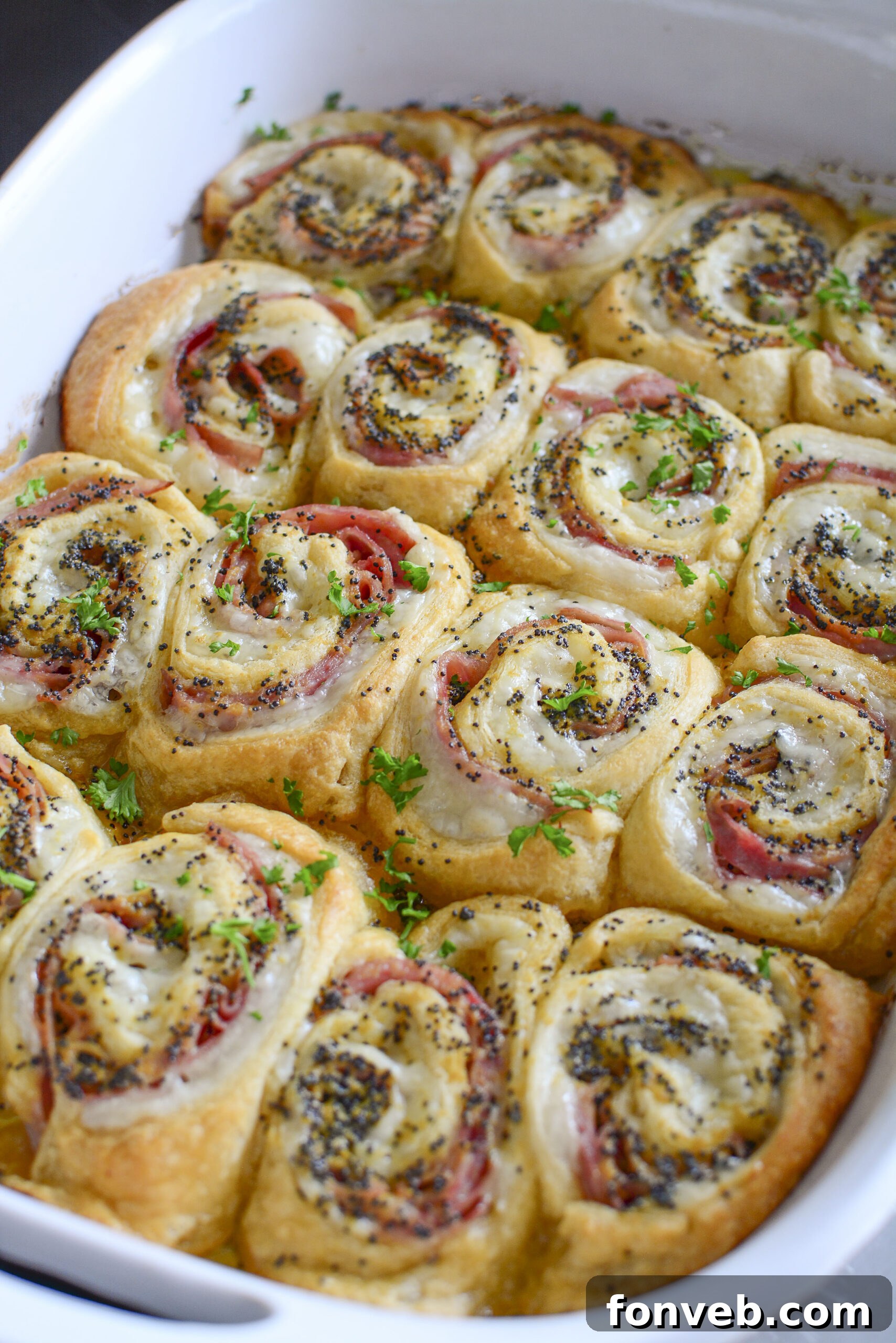 Ham and Cheese Pinwheels in a white baking dish side angle