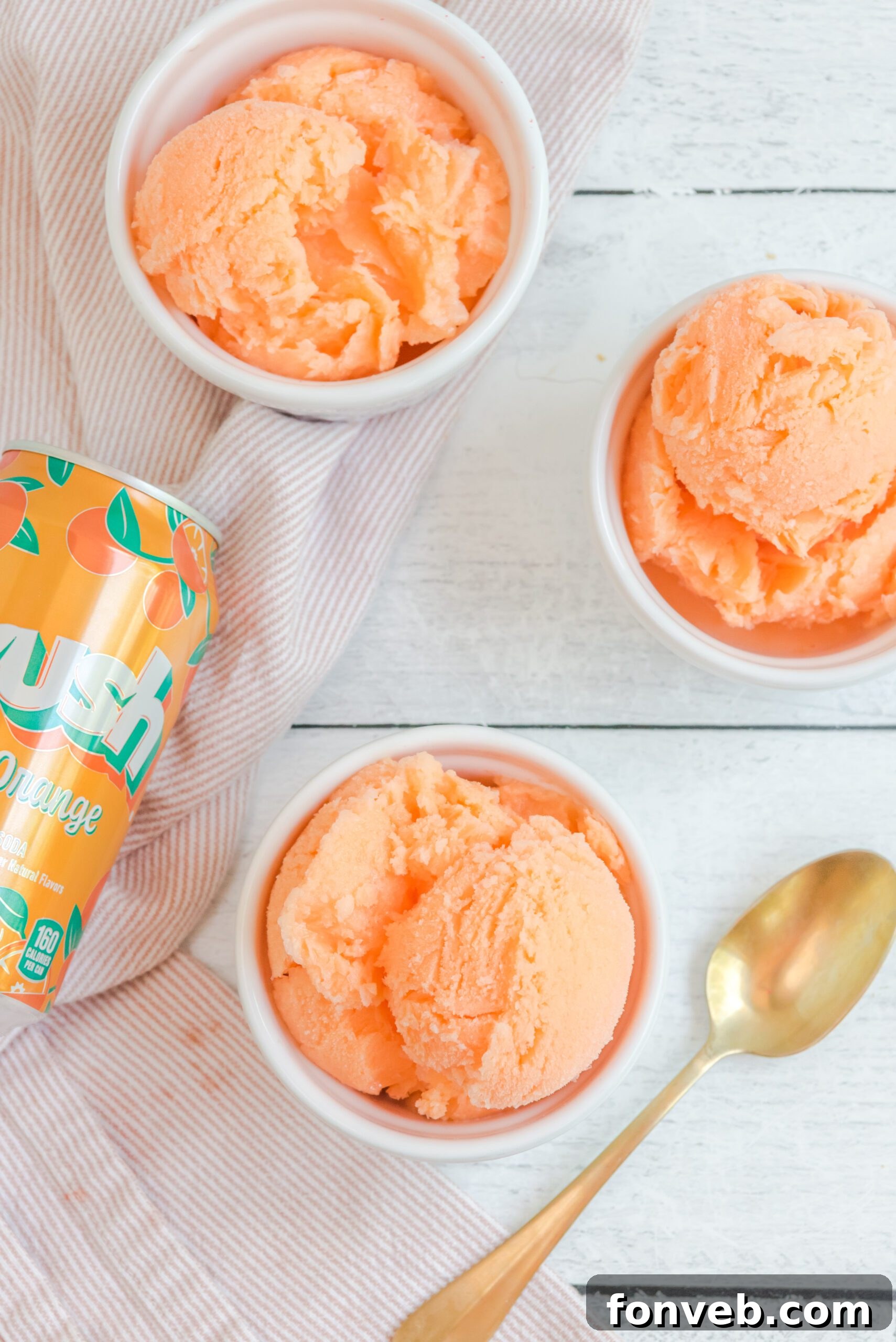 Three bowls of Orange Crush Sherbet artfully arranged, alongside a can of Orange Crush soda