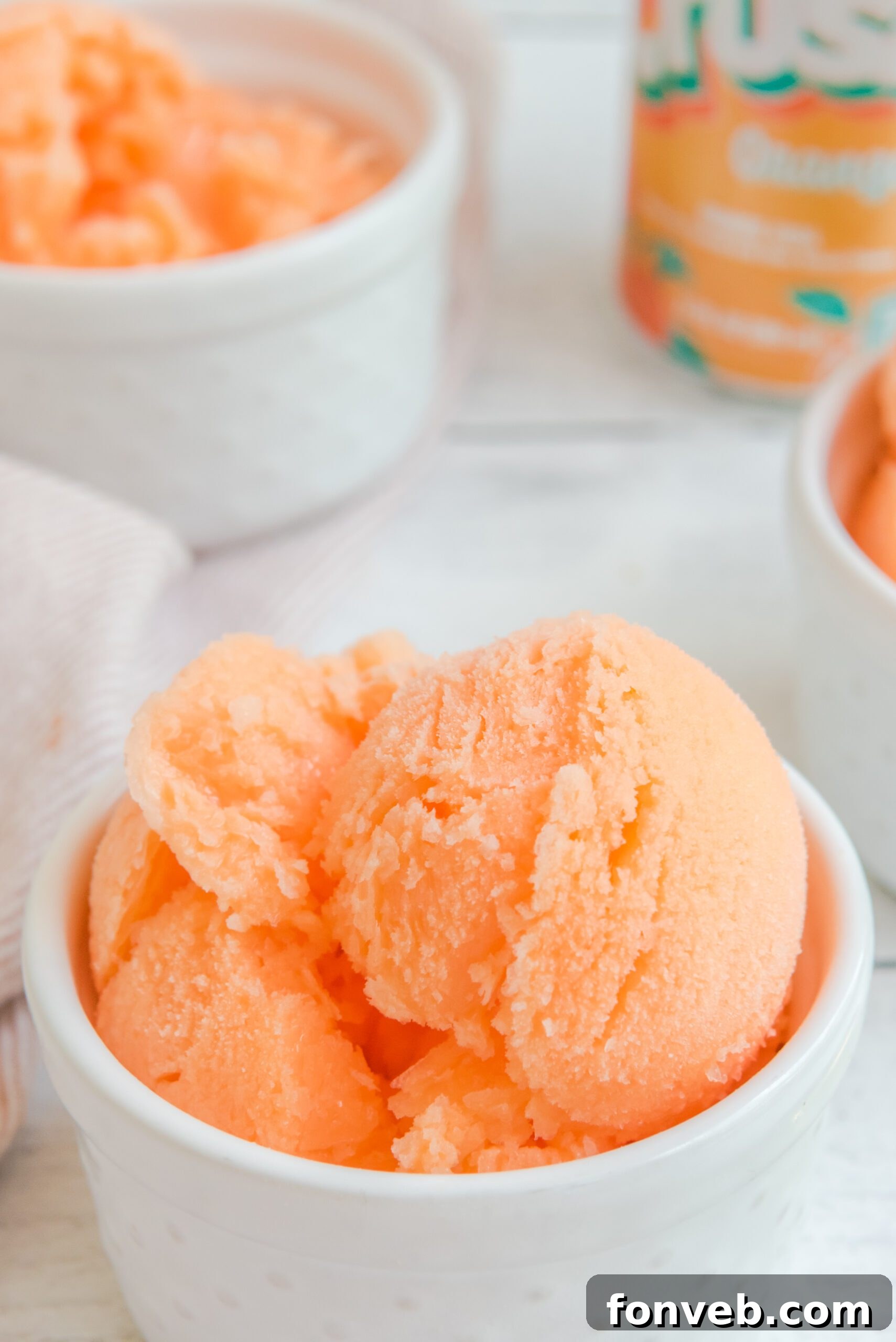 A trio of white bowls filled with refreshing Orange Crush Sherbet