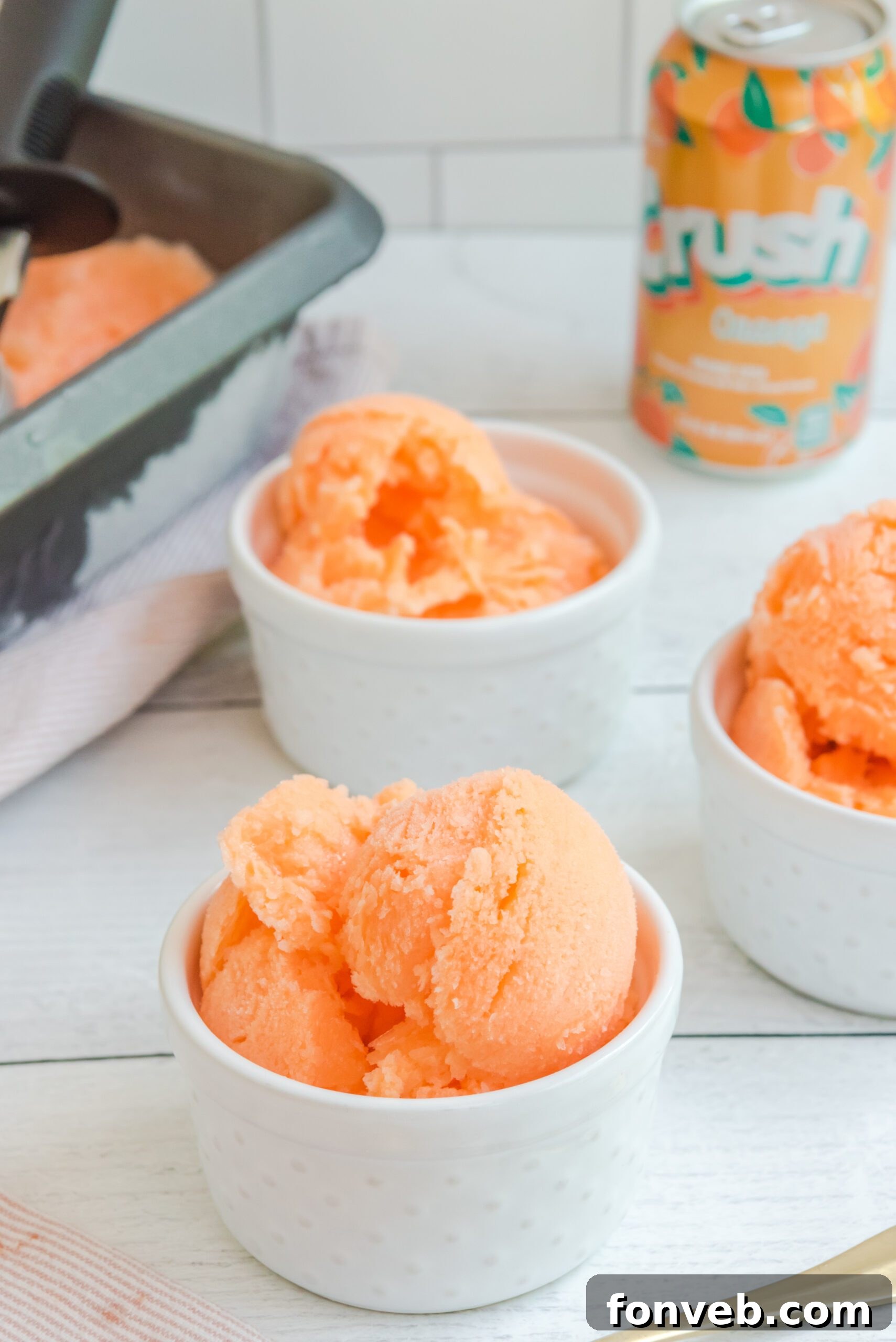 A close-up shot of Orange Crush Sherbet in a white bowl, highlighting its vibrant color and appealing texture