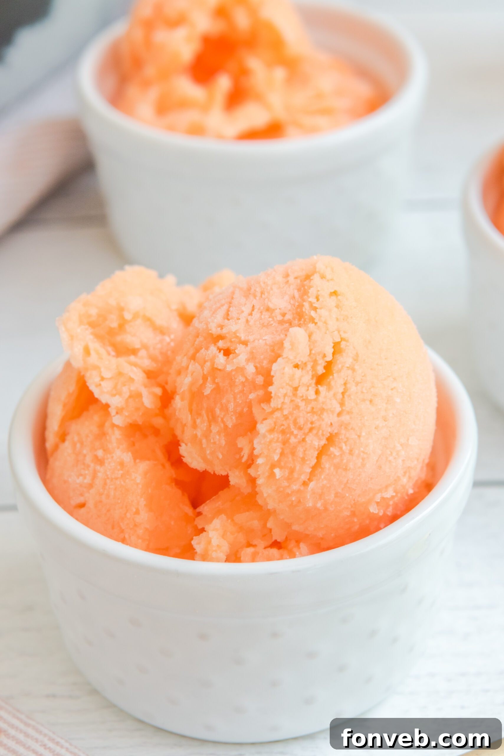 Close-up view of Orange Crush Sherbet in a white bowl, emphasizing its smooth and luscious texture