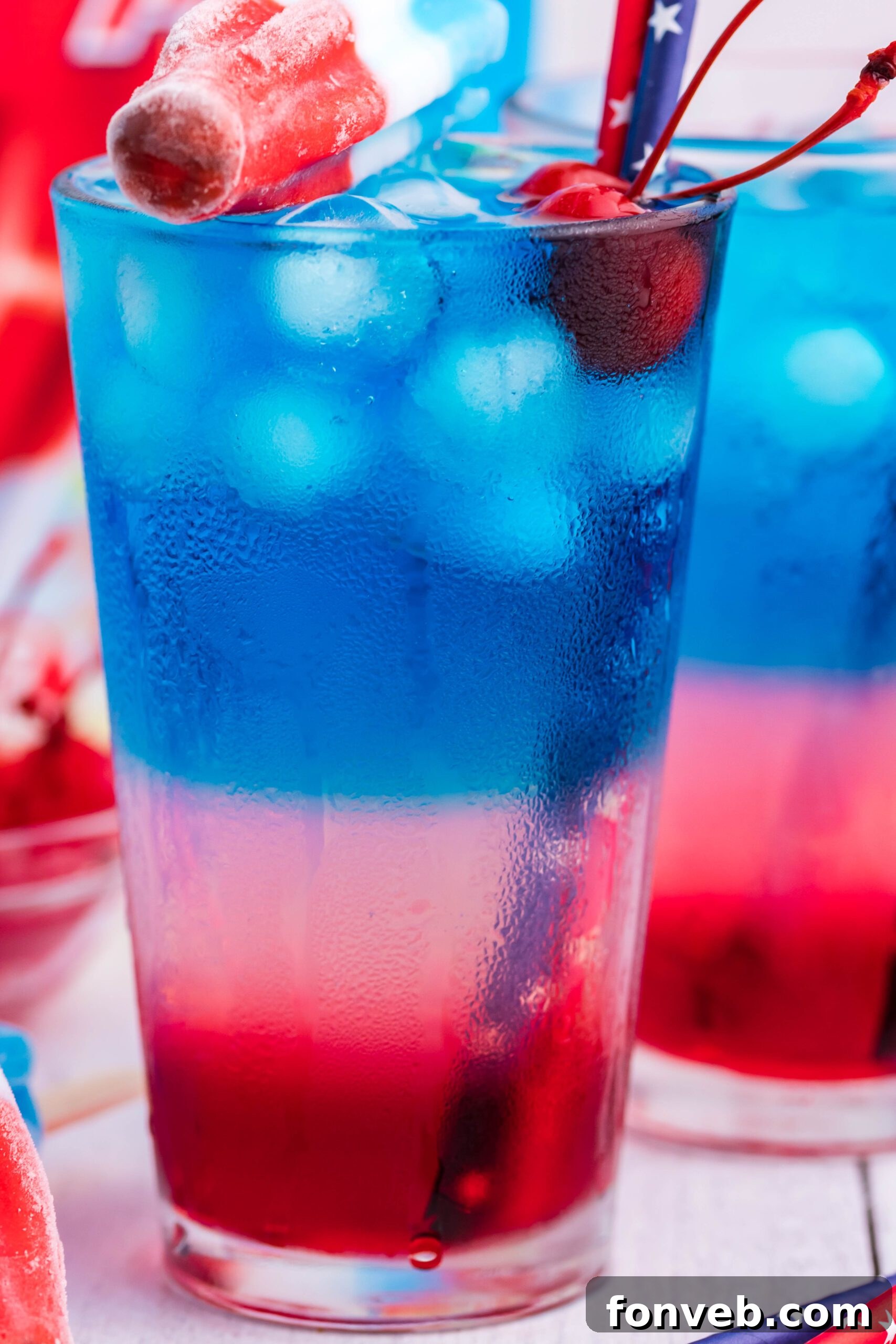Bomb Pop Cocktail Drink in a clear glass with a blue straw