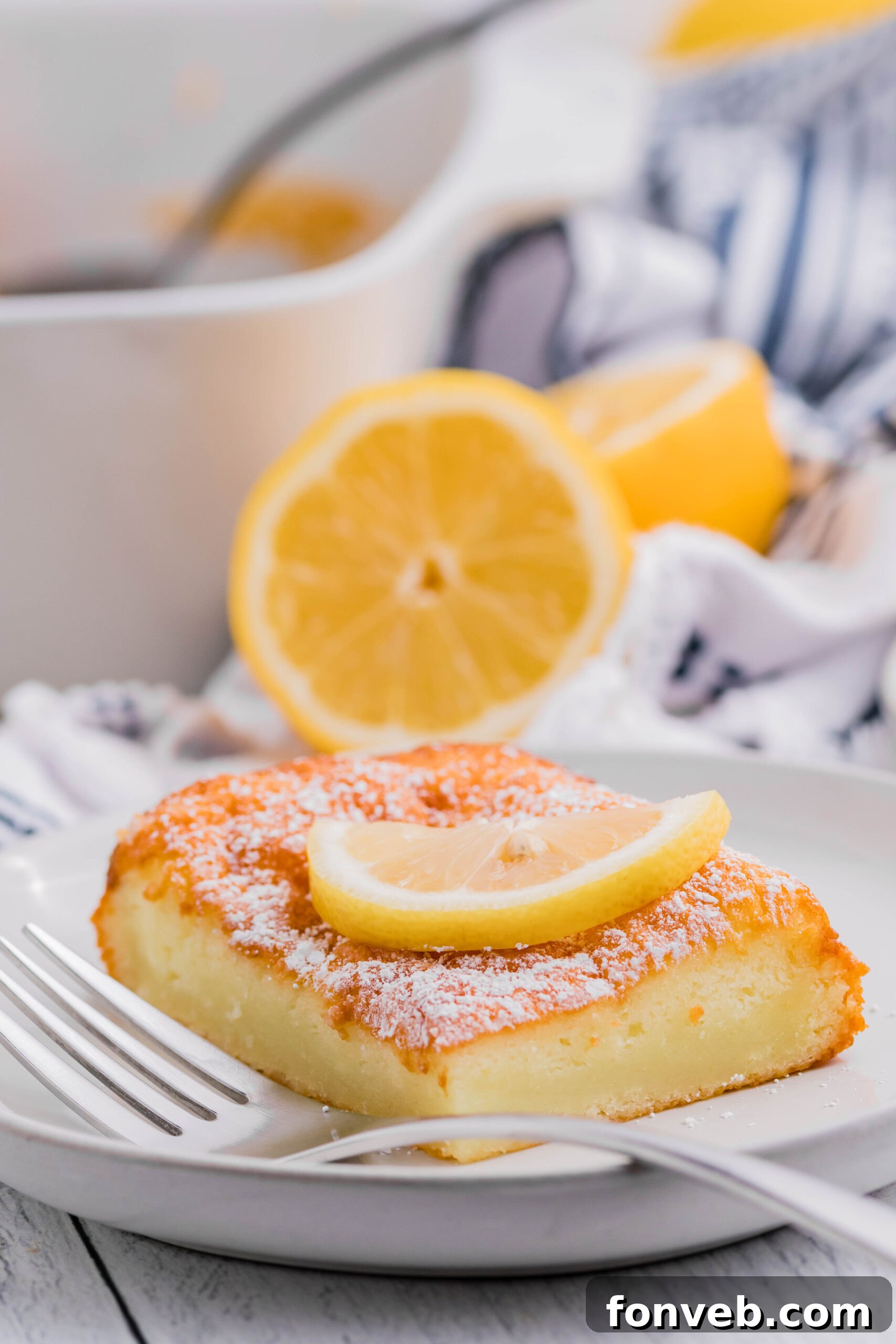 2 Ingredient Lemon Bar slice on a white plate with powdered sugar on top