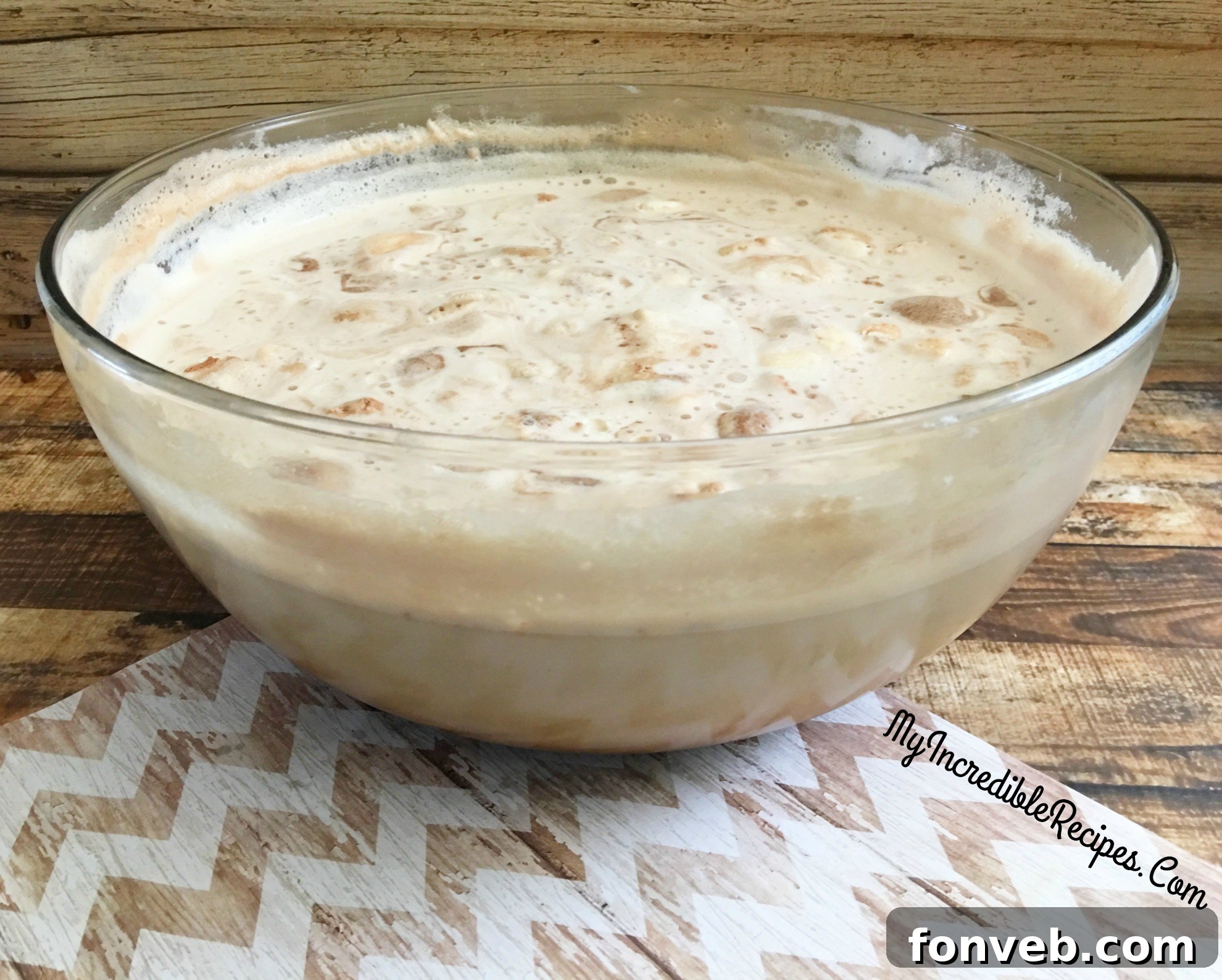 Coffee punch in a large glass bowl with a ladle, surrounded by glasses