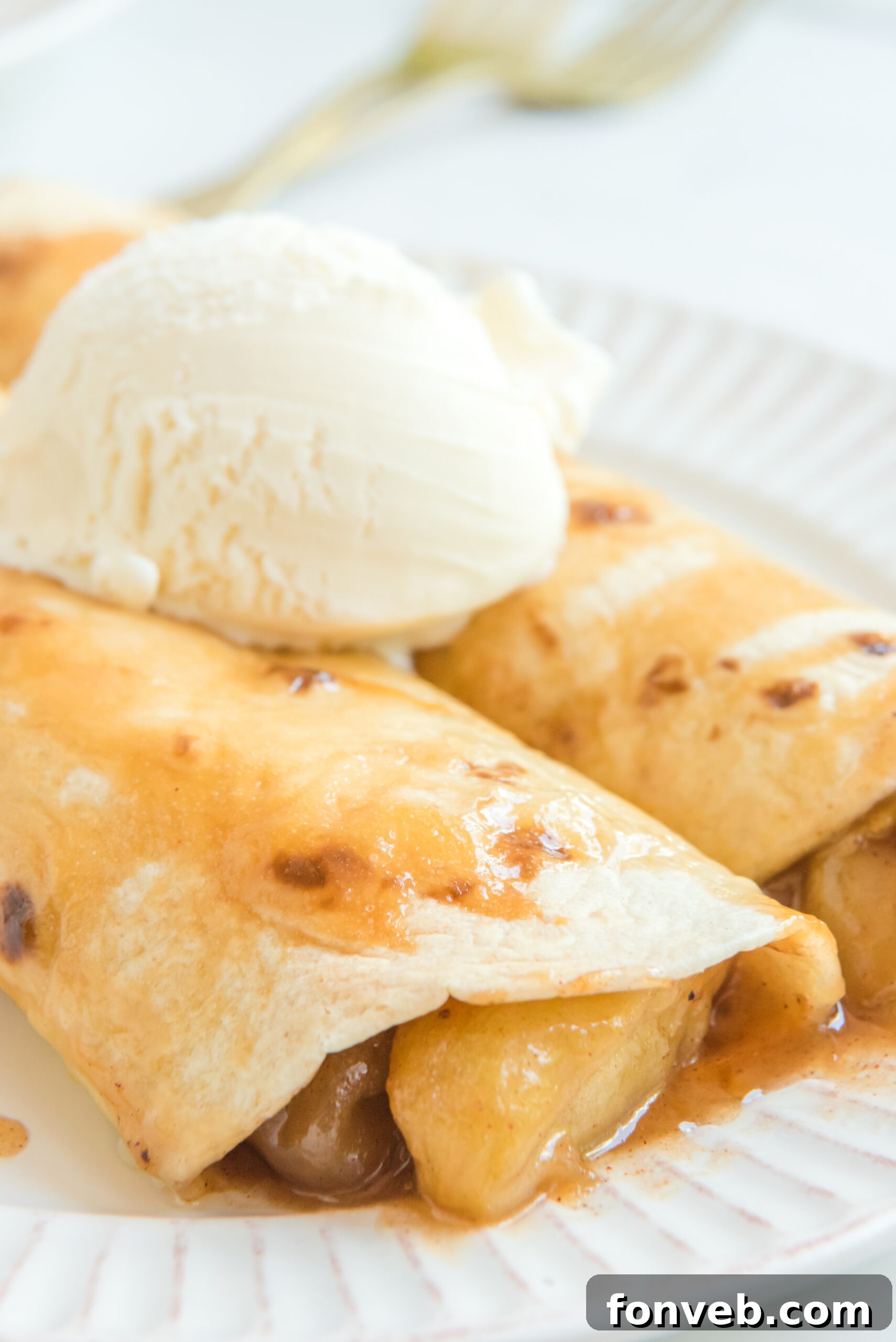 Apple Pie Enchiladas topped with vanilla ice cream close up